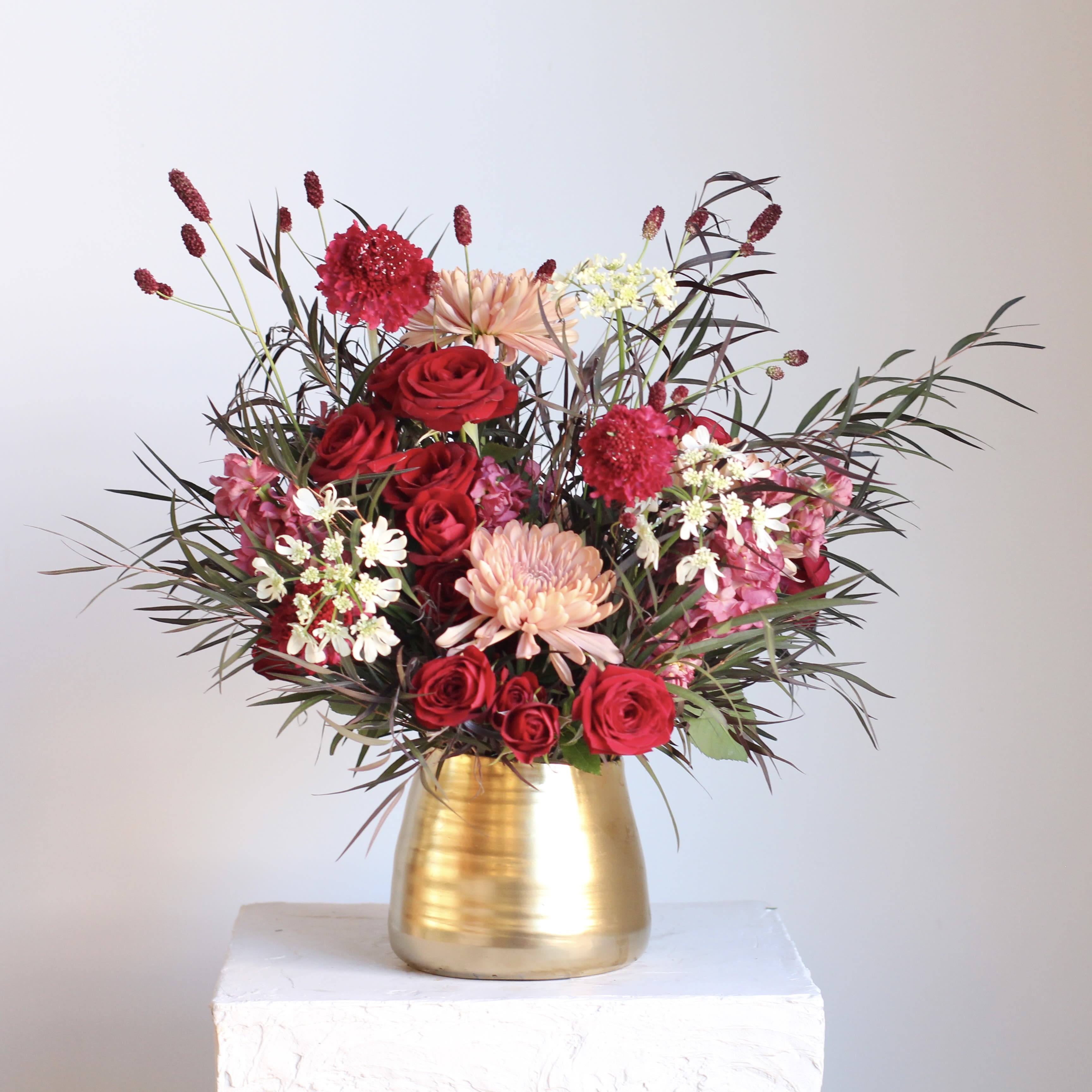 Crimson Kiss  - Our Crimson Kiss arrangement is a bold and romantic design featuring rich red blooms styled in a sleek gold container. Lush, dramatic, and timeless, this striking arrangement is perfect for making a statement whether for love, celebration, or just because.  Delivery Policy: At Middlemist, we aim to make every delivery seamless and delightful. It is the sender’s responsibility to ensure the recipient is available to accept delivery between 3–5pm on the scheduled date and that the delivery address is accurate. We will send a text notification to the recipient on the day of delivery. If no one is available to receive the order, it will be returned to the shop and may be picked up or redelivered for an additional delivery fee. If a recipient requests the order be left unattended, we cannot guarantee the condition of the flowers or plants, and no refunds will be issued once an order is left outside.