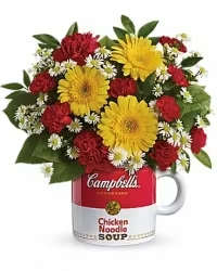 Bouquet of red and yellow flowers arranged in a soup mug