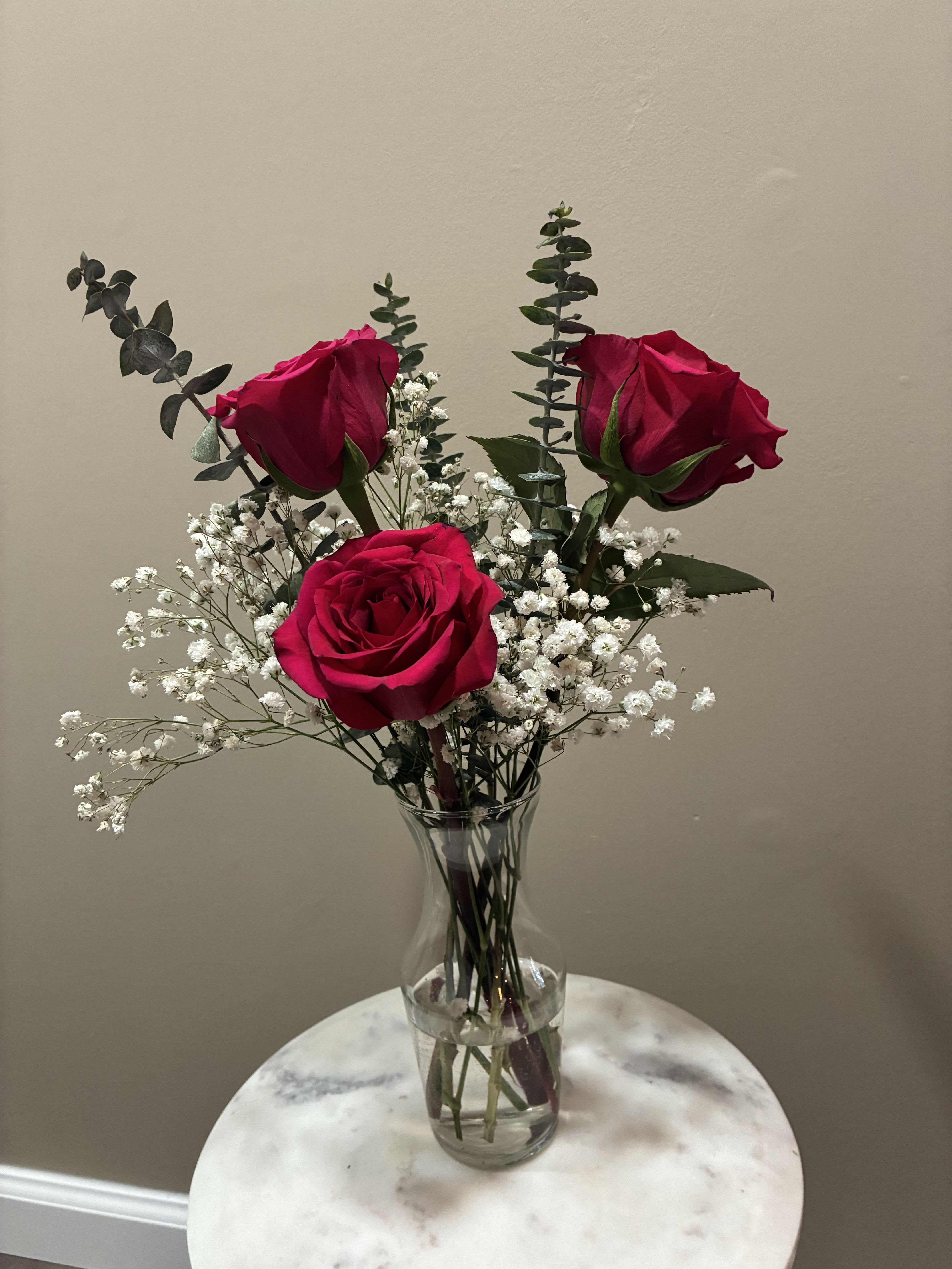 A Little Love - Three fresh roses arranged with greenery in a petite vase. Perfect for a thoughtful surprise, a desk arrangement, or sending a little love someone’s way.