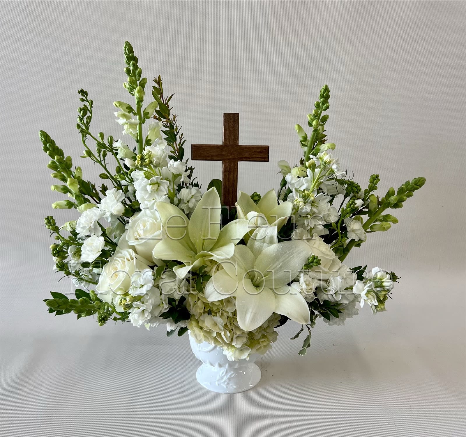 Eternal Faith - A modest wooden cross keepsake with a walnut finish, designed with mixture of all white flowers.
