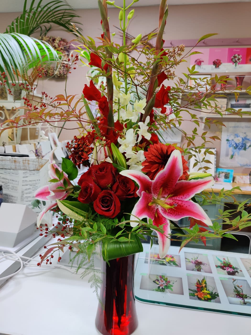 Greatest Love of All - Contains Gladiolus, Orchids, Roses, Stargazer, Dahlia, Cox in a Tall Red Vase 
