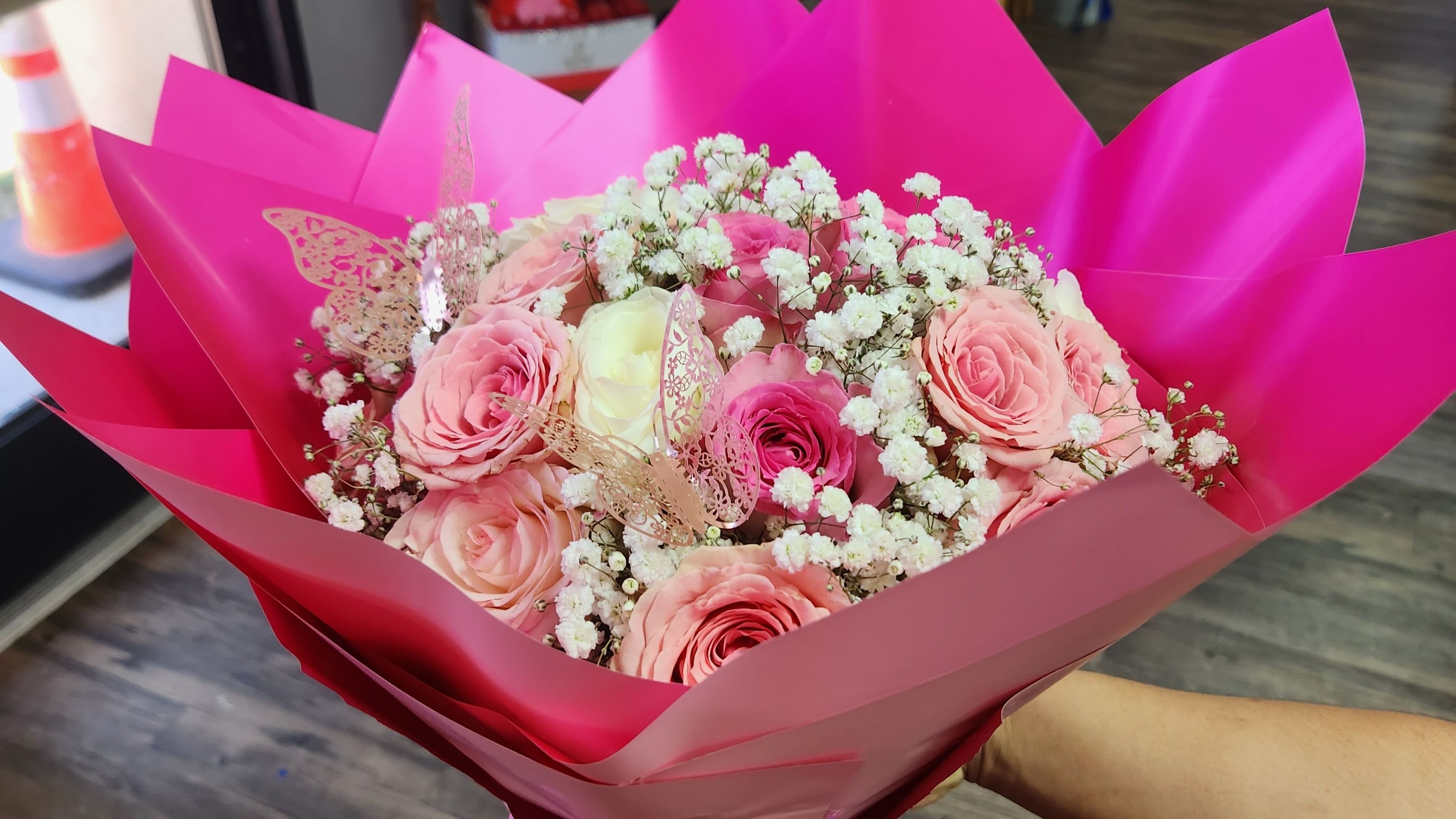 Blush of Love - Perfect for any celebration, this beautiful bouquet pairs the timeless charm of pink roses with airy baby's breath. The luxe waterproof wrapping adds a sophisticated touch, ensuring your gift looks fresh and flawless from the moment it’s received.