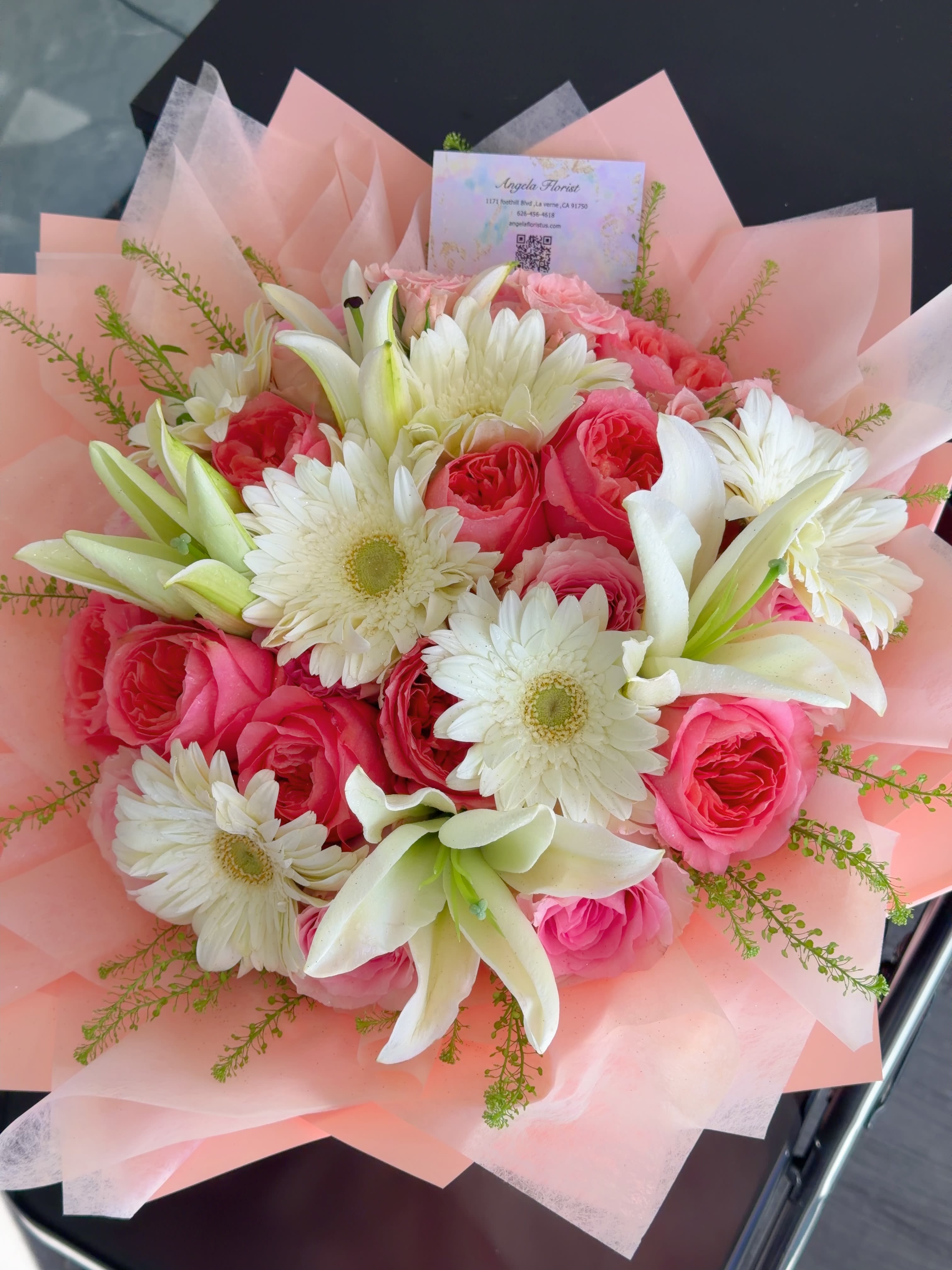 Pink Elegance Bouquet - A charming bouquet of soft pink roses, white lilies, and fresh gerbera daisies, accented with delicate greenery. Hand-arranged and wrapped in elegant blush paper, it’s perfect for birthdays, anniversaries, celebrations, or brightening someone’s day.