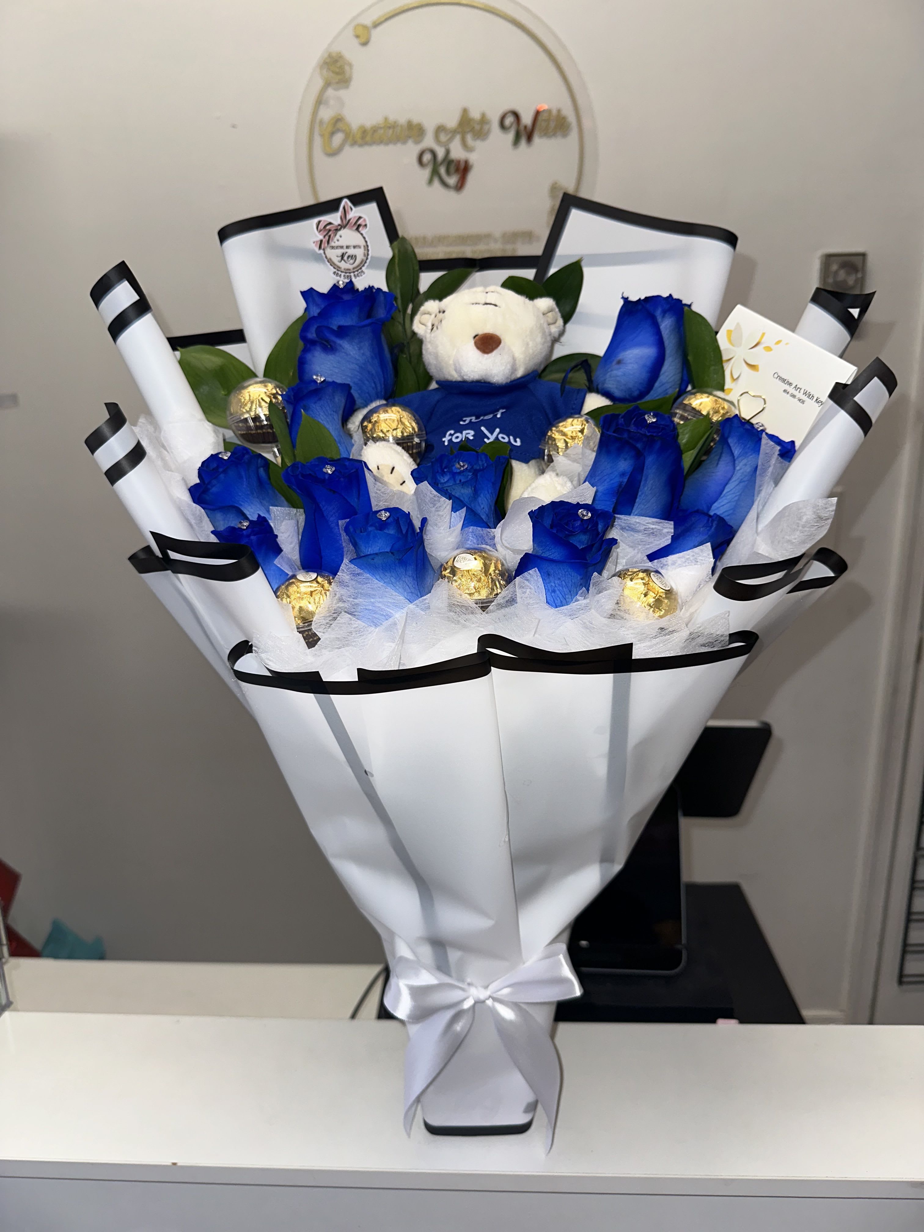 Beautiful arrangement with blue roses, teddy bear in the center, Ferrero Rocher chocolates encapsulated in acrylic - Beautiful arrangement with blue roses, teddy bear in the center, Ferrero Rocher chocolates encapsulated in acrylic