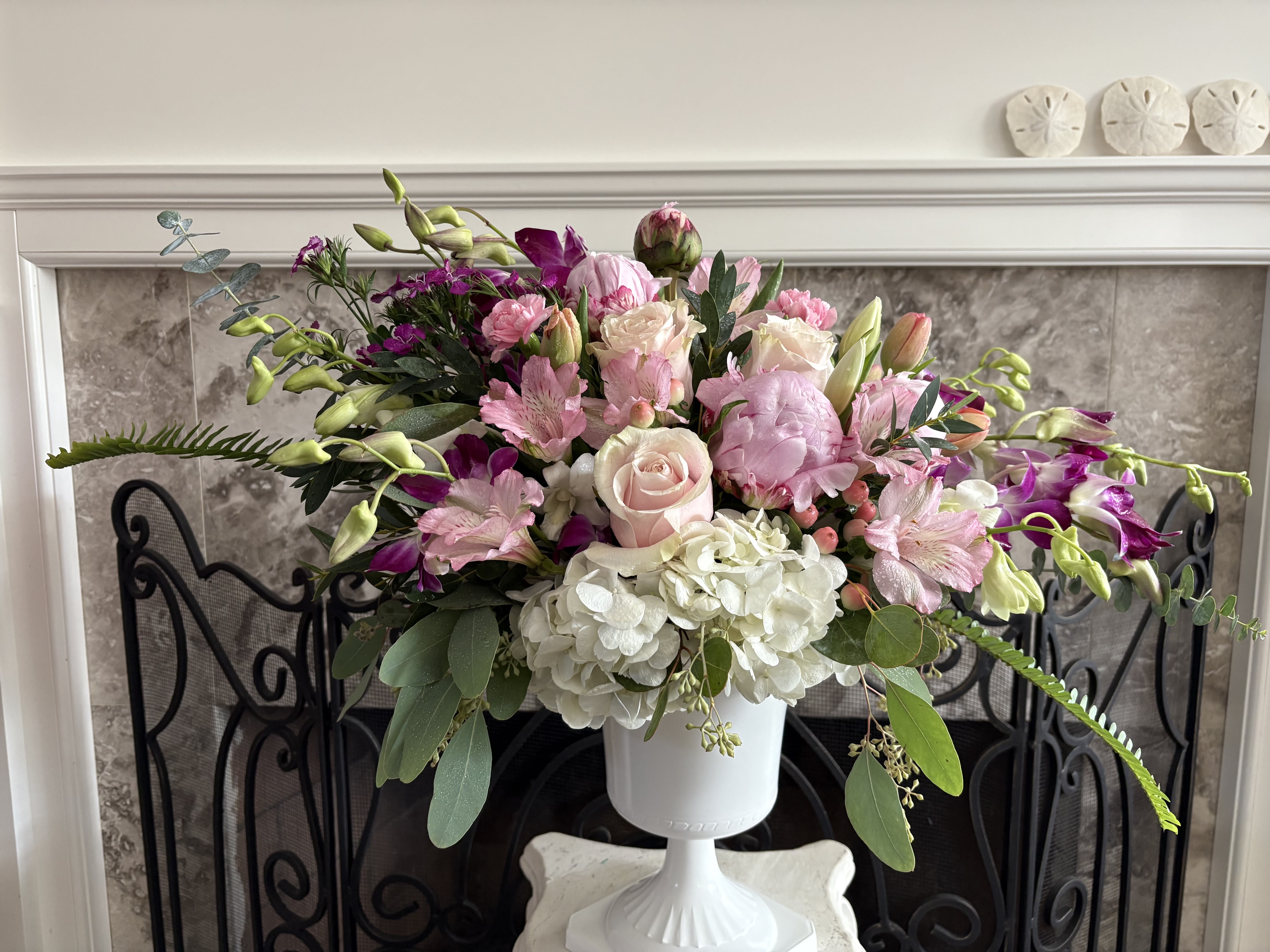 French Design : Pink Allure  - Eyes and hearts alike are drawn to this alluring and attractive arrangement full of fantasies, daydreams, and everything the color pink inspires. Take your recipient's breath away with this enticing pastel composition of blush pink roses, pink cymbidium orchids, elegant tulips, and white hydrangeas, surrounded by delicate dashes of greenery. The containers may vary depending on what is available, but guaranteed to be the same or higher than the original value.