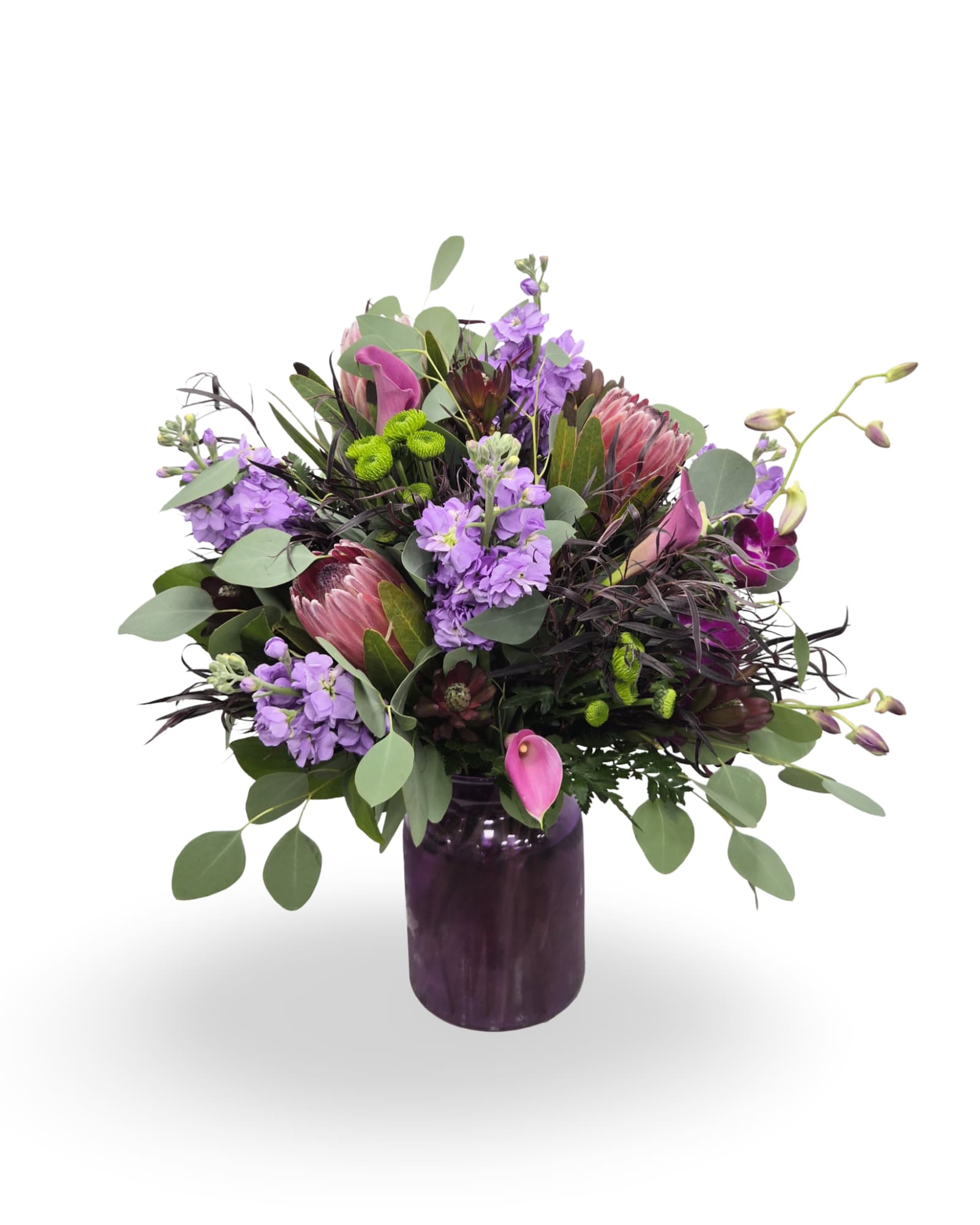 Enchanted Purple Garden - Select this lush arrangement of rich purple and pink florals accented with greenery, designed in a sleek purple vase. Perfect for any occasion.  Approximately 20” x 15” x 11” 