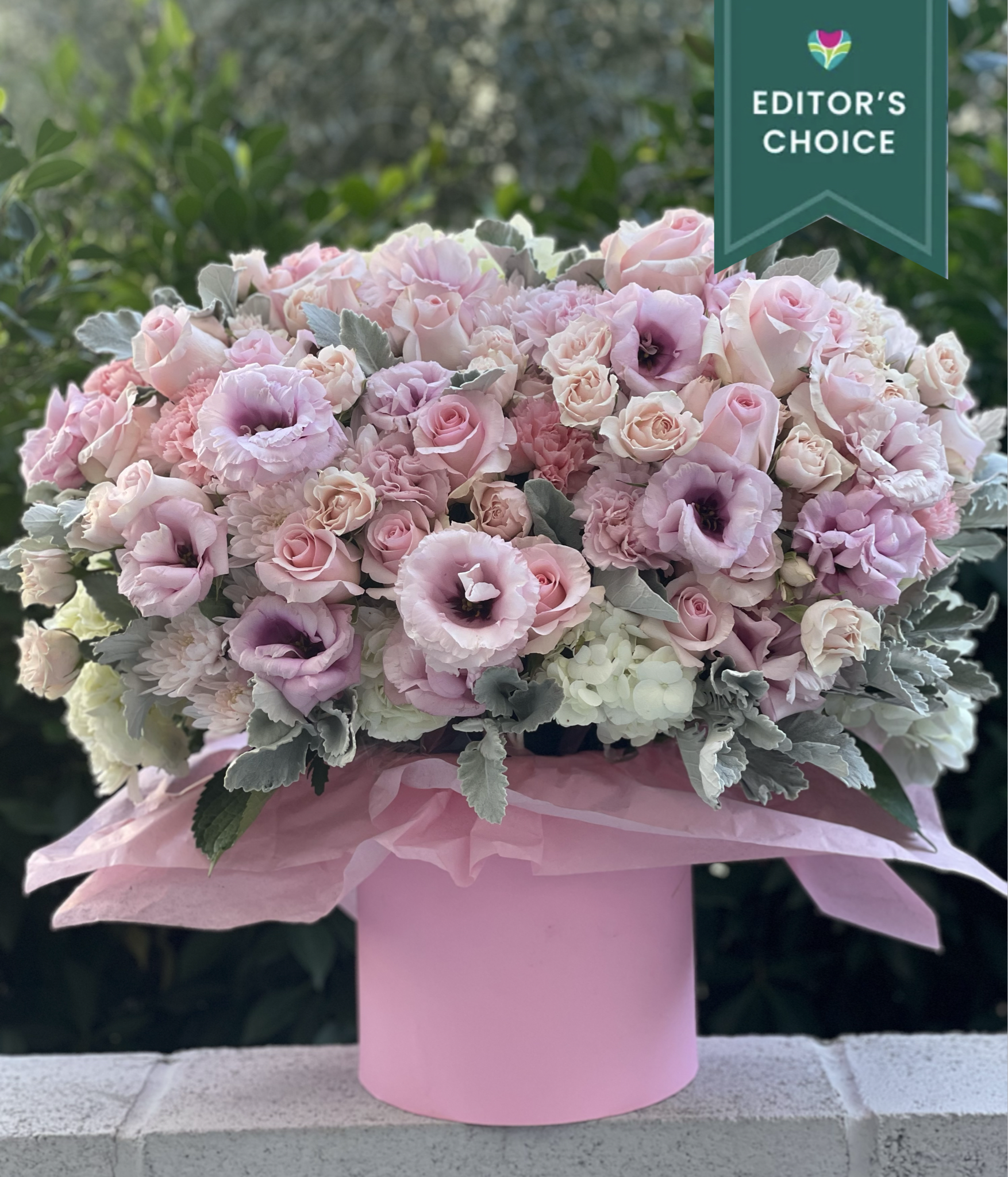Large pastel pink and white floral arrangement in a round pink hatbox