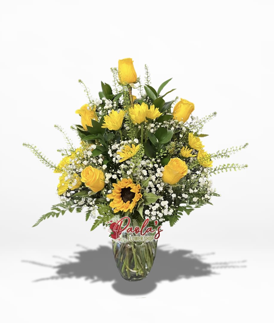 Yellow roses and a sunflower in a glass vase