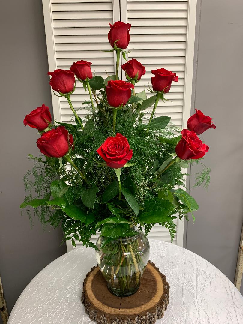 Dozen Rose Vase Arrangement with Assorted Greenery - For the perfect, traditional Valentine’s Day bouquet – or for a birthday, anniversary or other special day – this bouquet of a dozen red roses (no Filler Flower) is a classic gift of love. Send it today, and she’ll love you forever. Available in many colors.