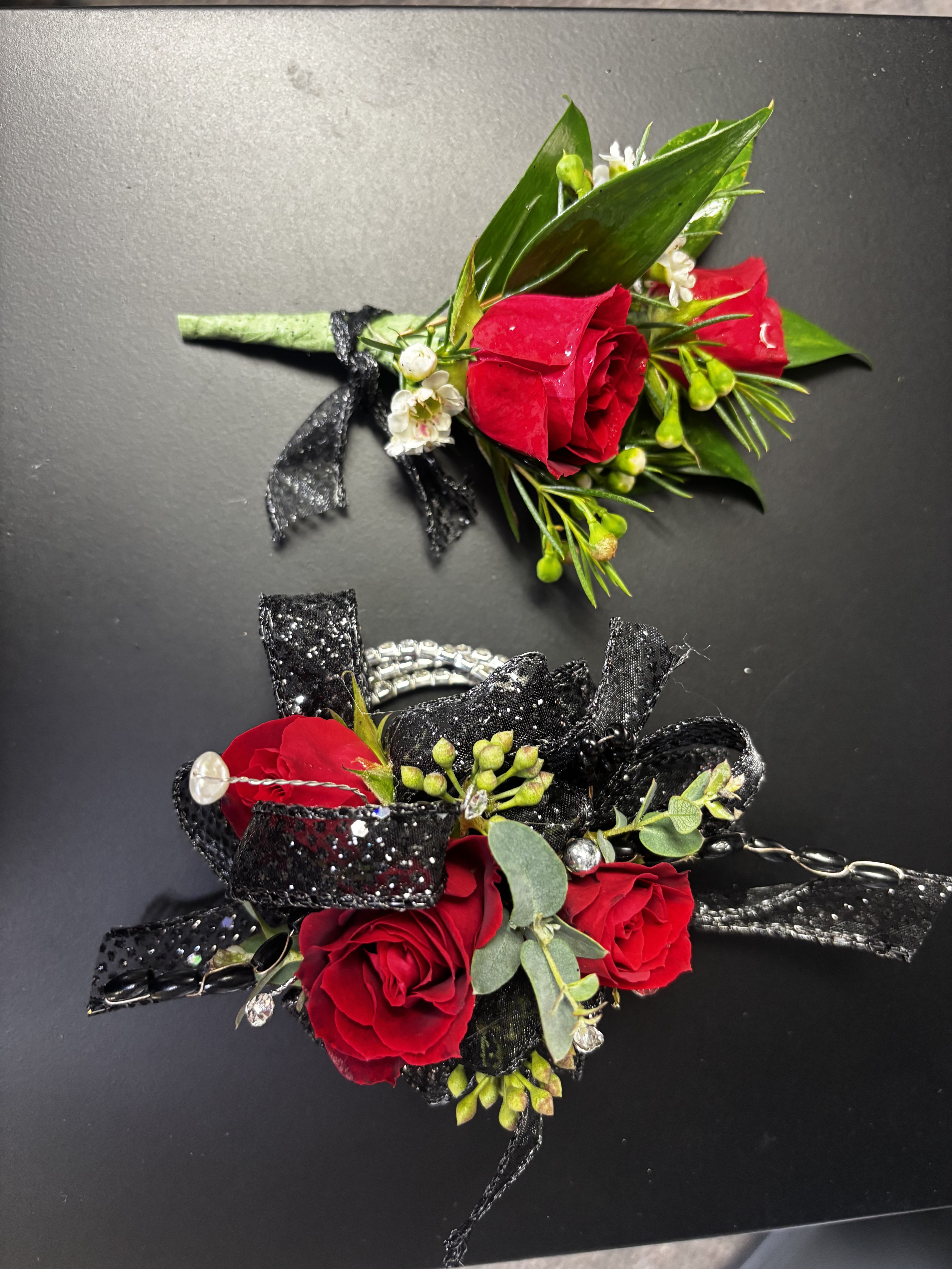 Ruby Elegance Duo - A striking corsage and boutonnière set featuring rich red roses, sparkling black ribbon, and elegant accents. Also a rhinestone wristlet. Daddy/Daughter Dance 