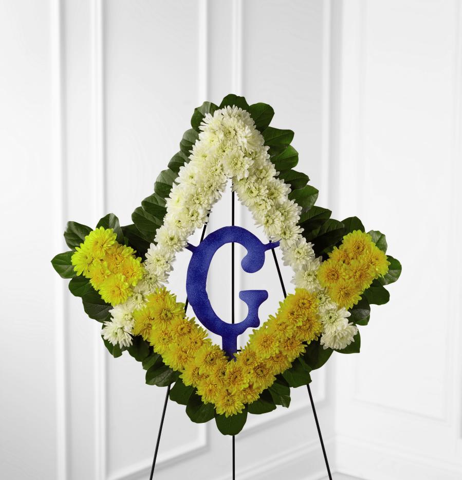 FTD Fond Reflections Tribute - The FTD Fond Reflections Tribute is a lovely way to commemorate   the life of the deceased. Arranged in the symbol of Freemasonry are   white and yellow chrysanthemums and lush greens accented with a   Styrofoam(r) Masonic Blue Lodge Emblem, and a royal blue ribbon, to   symbolize the devotion of the departed to his lodge at the final   farewell service. Displayed on a wire easel.      24""h x 24""w
