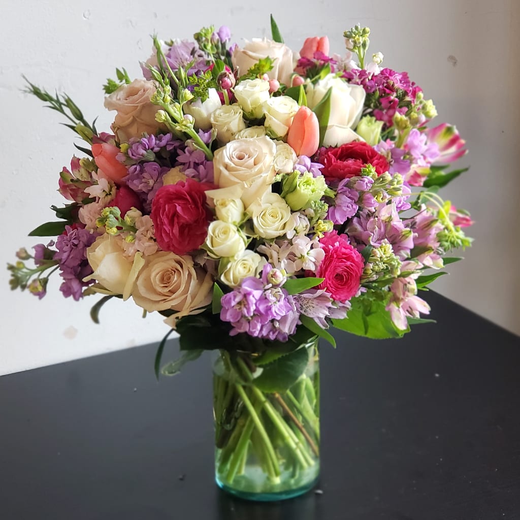 How Sweet Bouquet - Experience the joy of gifting with How Sweet Bouquet. This charming mix blends soft romance with vibrant color, perfect for any special moment. Designed to brighten birthdays, anniversaries, or any heartfelt occasion.  Features: - A medley of creamy roses - Blush tulips and deep pink blooms - Accented with lush seasonal greenery  Approximately 18" H x 15" W. Send beauty and warmth in this one unforgettable bouquet.