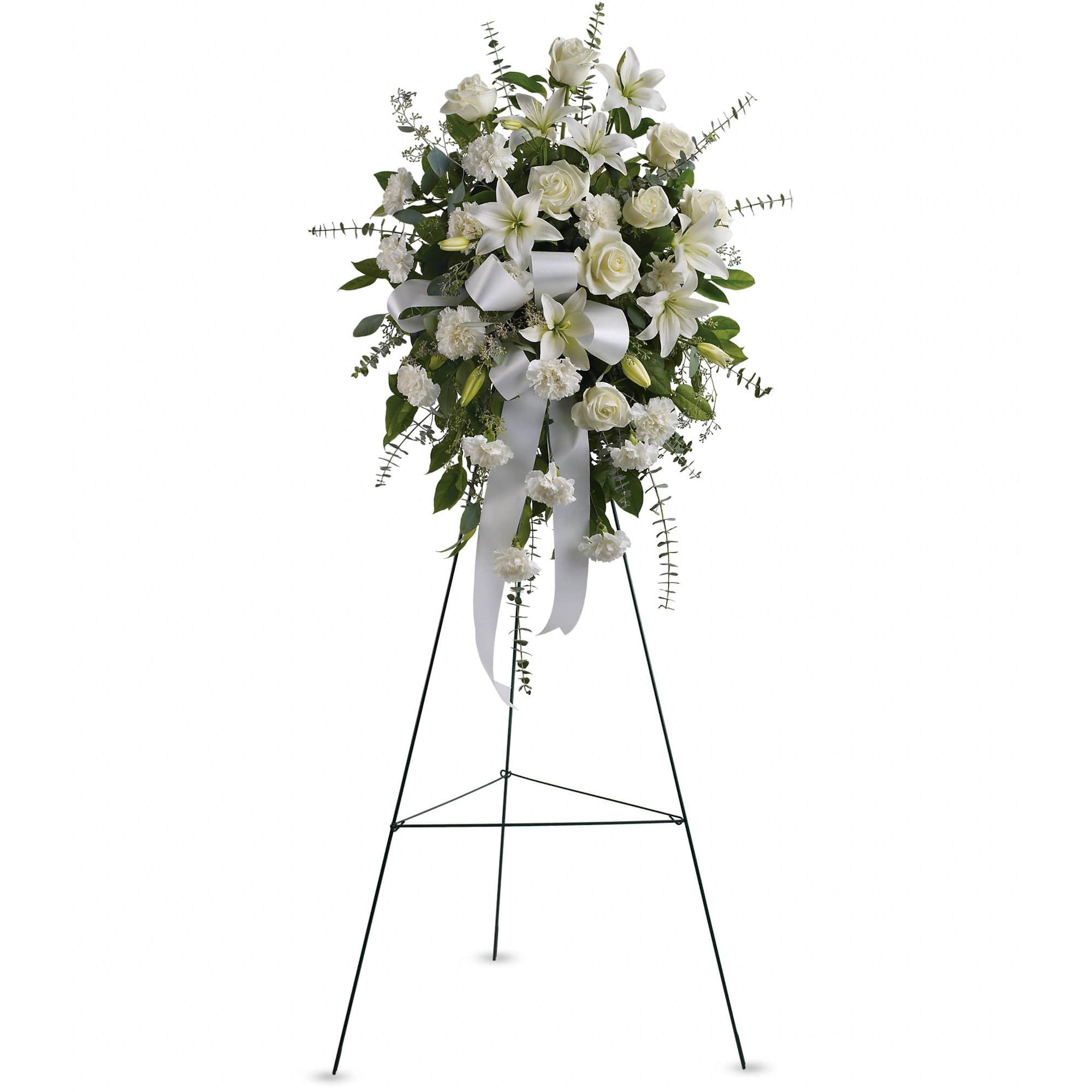 Sentiments of Serenity (Easel Stand) - Beautifully simple, this lovely spray of white roses, lilies and carnations decorated with white satin ribbon is a tasteful way to express your sympathy.  