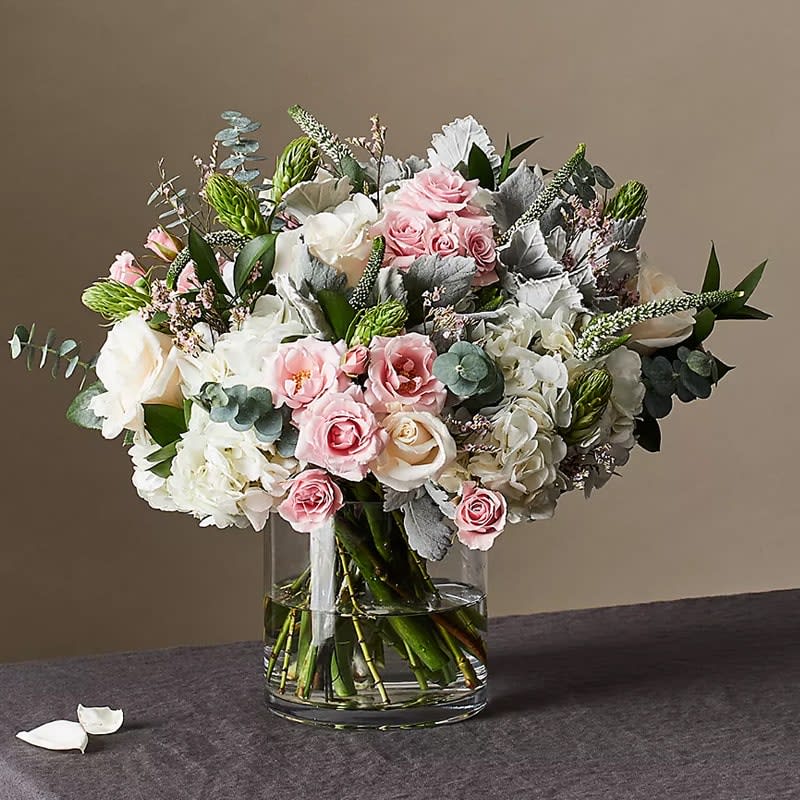 Everyday Glow - Everyday Glow Arrangement is designed with cream roses, white hydrangea, pink spray roses, white Star of Bethlehem, Dusty-miller, and seasonal accents.   Perfect for birthdays, anniversaries, congratulations, or simply to brighten someone's day with a thoughtful gesture.  Approximately 16" H x 16" W. 