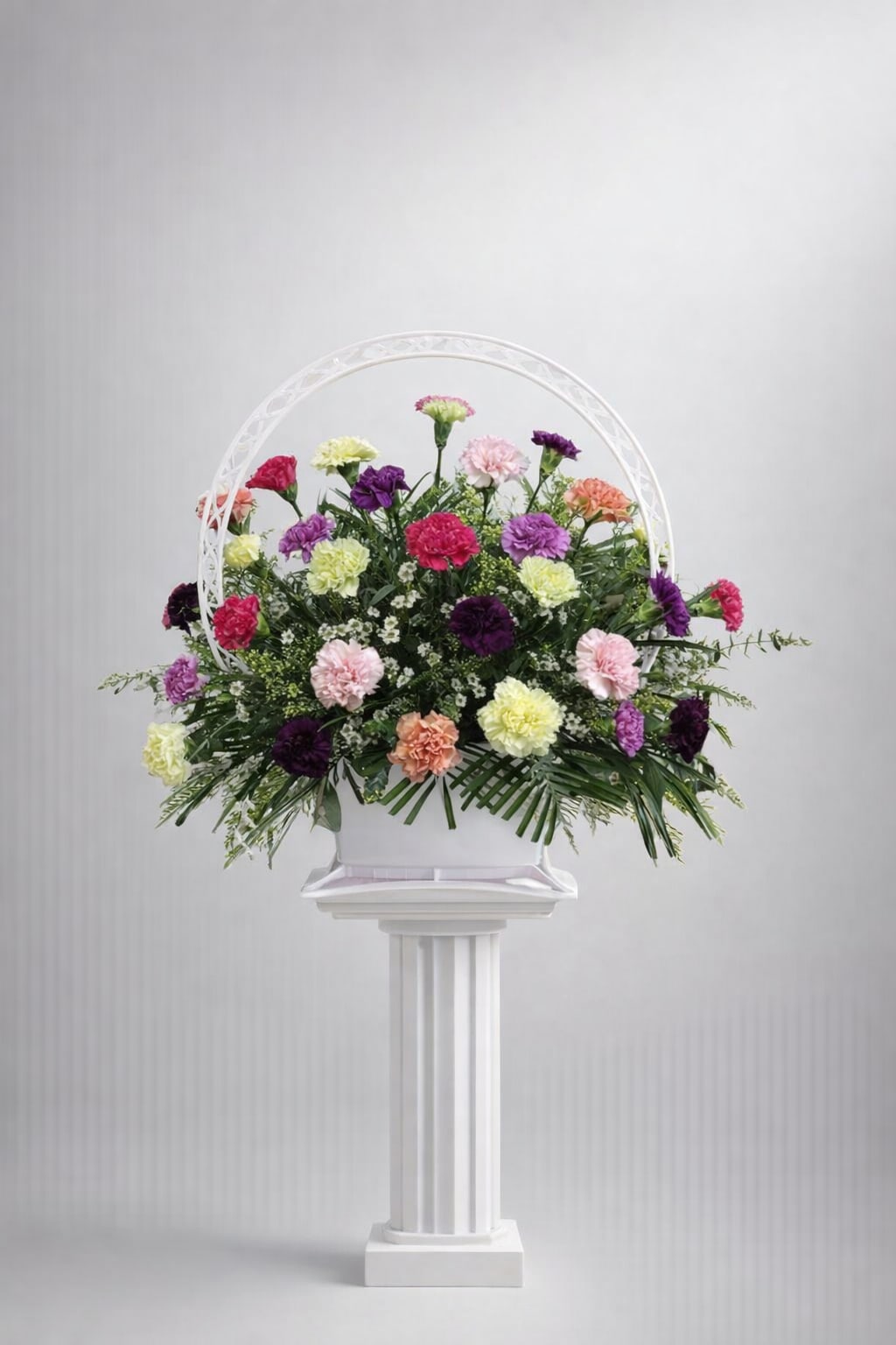 Carnation Comfort Basket - Celebrate the beauty of life with our Carnation Comfort funeral basket, a heartfelt tribute designed to bring solace during difficult times. This traditional arrangement features a stunning array of vibrant carnations, artfully combined with lush greens and delicate fillers, creating a comforting presence that honors your loved one’s memory  **When crafting floral arrangements, we aim to replicate the image as closely as possible. Remember, each design is one-of-a-kind and tailored specifically for you. Given the characteristics of flowers, some color adjustments may be necessary. Additionally, the prices and availability of seasonal blooms can vary.