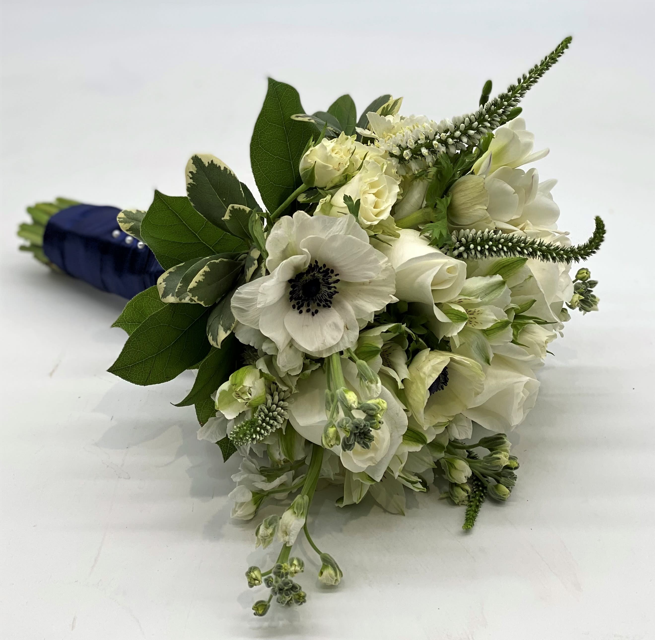The Masquerade Clutch Bouquet - Lush whites with the beautiful pop of a white anemone with dark center!. Great compliment to dark colored dresses!