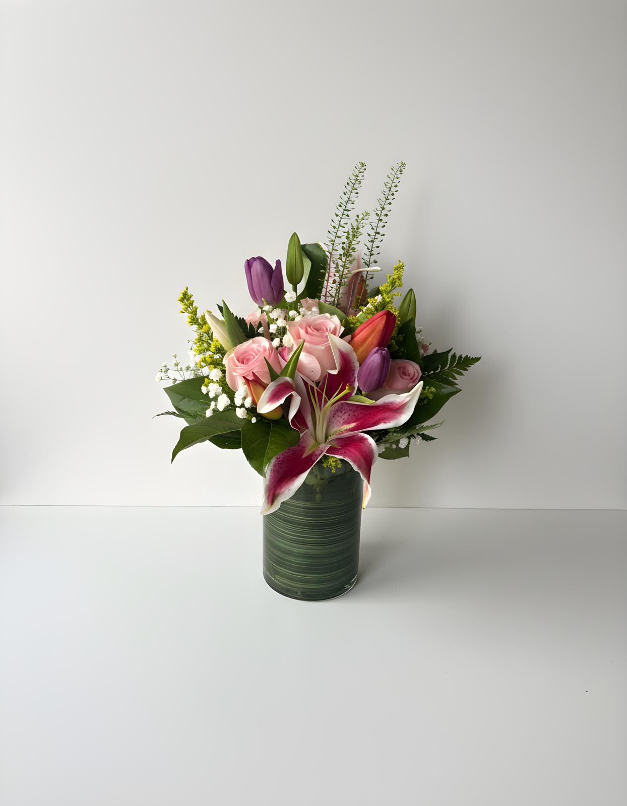 Florist’s Signature Designer Arrangement - Let our florist create something truly special with our Designer’s Choice Floral Arrangement. This arrangement allows our designer to use the freshest seasonal flowers available, thoughtfully arranged in a modern vase with complementary greenery for a beautiful and unique presentation.  Perfect for customers who trust our creativity and want a one-of-a-kind floral design, each arrangement is handcrafted with care and may include a mix of premium blooms such as roses, lilies, tulips, seasonal flowers, and lush greenery.  The photo shown represents the overall style, size, and color balance of the arrangement. Flower varieties may vary depending on seasonal availability, but the vase style, overall fullness, and designer aesthetic will remain similar.  Every Designer’s Choice arrangement is made with artistic freedom to ensure the freshest, most beautiful flowers available on the day of your order.