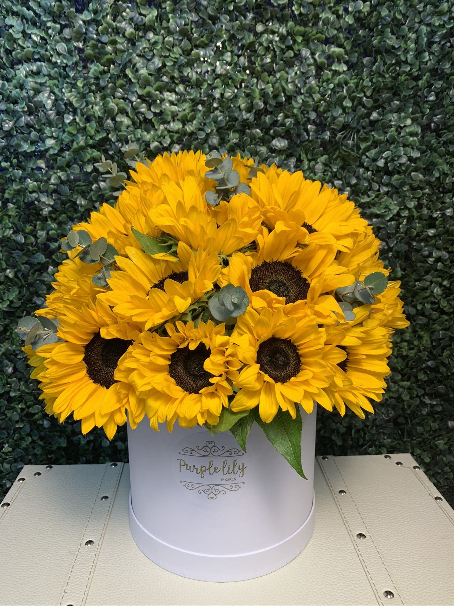 Yellow sunflowers arranged in a white hat box