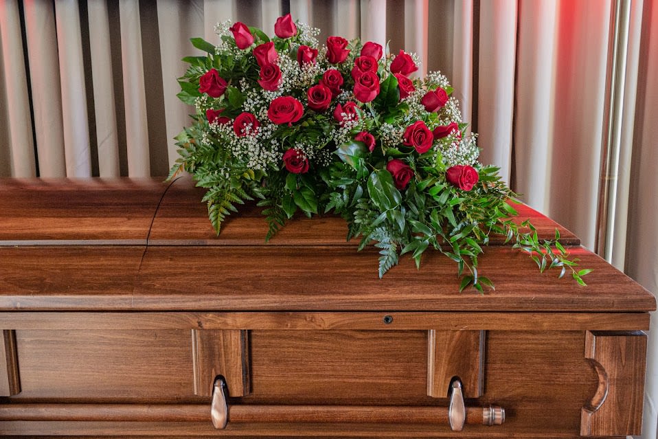 FUNERAL QUARTER CASKET SPRAY - Remembrance in Roses 30 - This is a stunning option for a funeral service or church. This casket spray is a smaller scale spray that will add a touch of flowers to the top of the casket. This spray can also be made into a half casket spray for an open casket service or a full casket spray for a closed casket service. The piece highlights the beauty of red roses in a simple and elegant manner that will be appropriate for any service.   **This is a piece for a funeral or memorial service. Please place the order at least 2 days prior to the service to guarantee a certain arrangement. Anything sooner and we cannot guarantee it will match the picture. These pieces can be customized to the color of your choice. The flowers may vary depending on availability of the flowers, special requests and quality of the flowers we have in stock. If you have a special request please add it to our special instructions when placing your order. If you have any questions please don’t hesitate to call. 714 289 1123**