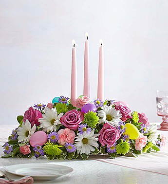 Easter Centerpiece - Get the party “hopping”! We’ve designed a fun and playful version of our favorite traditional centerpiece to celebrate Easter! A mix of soft pastel blooms is accented with colorful Easter eggs for a charming touch. Topped off with taper candles to cast a warm, cozy glow, it's a truly original way to share holiday smiles with family and friends.