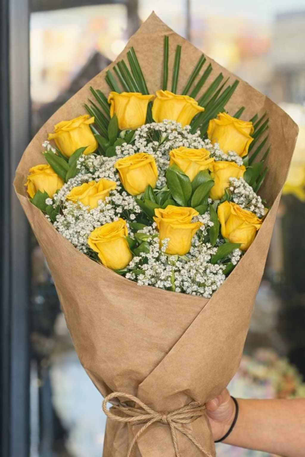 Sunny 12 Rose Bouquet  - A cheerful bouquet featuring 12 fresh yellow roses wrapped in Kraft paper with soft baby's breath and fresh greenery, creating a bright and timeless look. 