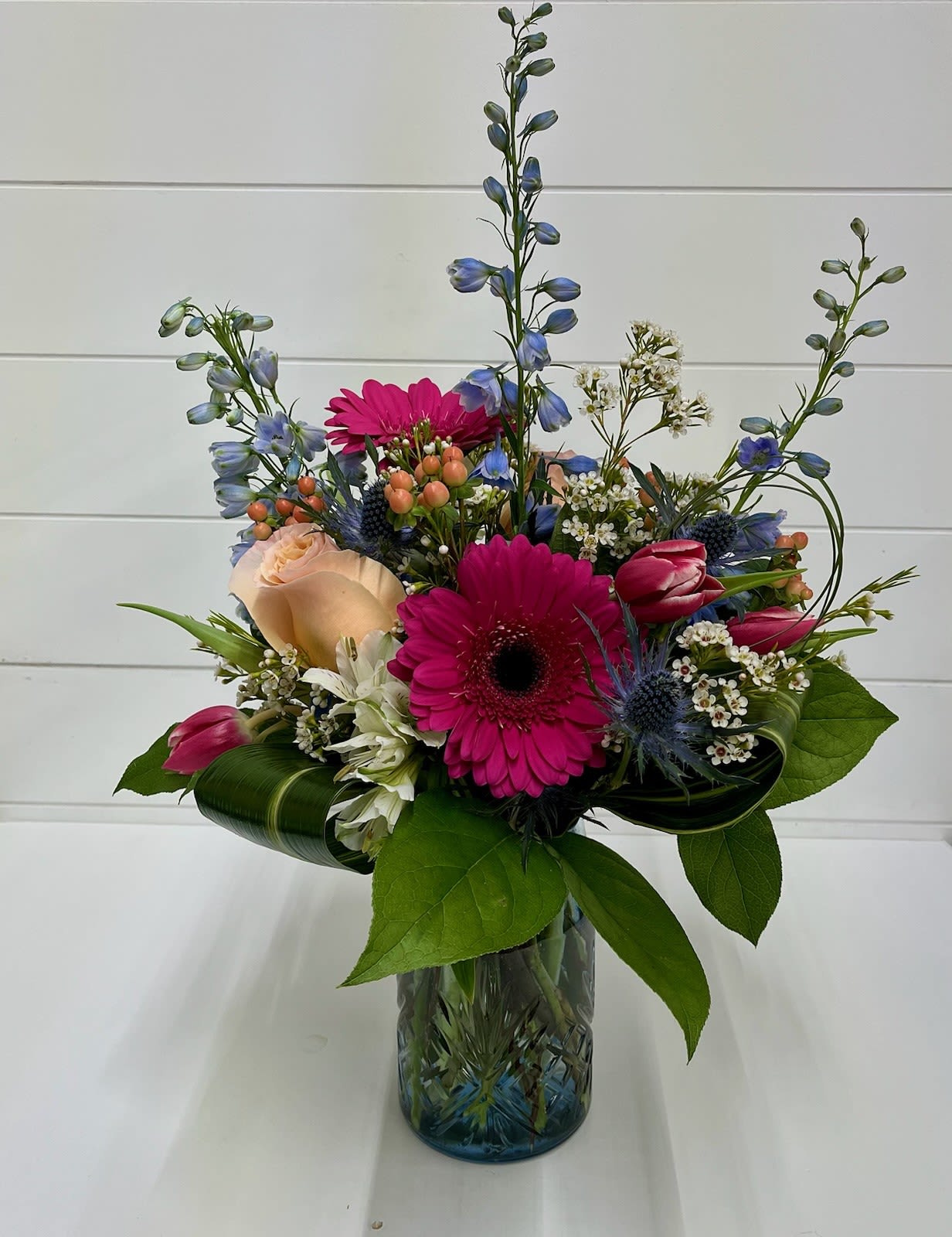 Peachy Sky - Soft, fresh, and full of spring charm, the Peachy Sky Arrangement brings together a dreamy blend of peach, blush pink, and airy blue tones. This garden-inspired design features cheerful gerbera daisies, elegant tulips, delicate roses, and vibrant alstroemeria, beautifully complemented by wisps of delphinium, textured thistle, and clusters of wax flower. Lush seasonal greenery ties everything together, creating a light, natural look that feels like a clear spring morning.  Perfect for birthdays, celebrations, thank-you gifts, or simply brightening someone’s day, Peachy Sky offers a soft yet joyful palette that captures the beauty of the season.  Local Flower Delivery Available: We proudly offer flower delivery for the Peachy Sky Arrangement in Smyrna, Marietta, Mableton, and Atlanta.  Flowers and specific varieties may vary based on seasonal availability while maintaining the overall color palette and design style.