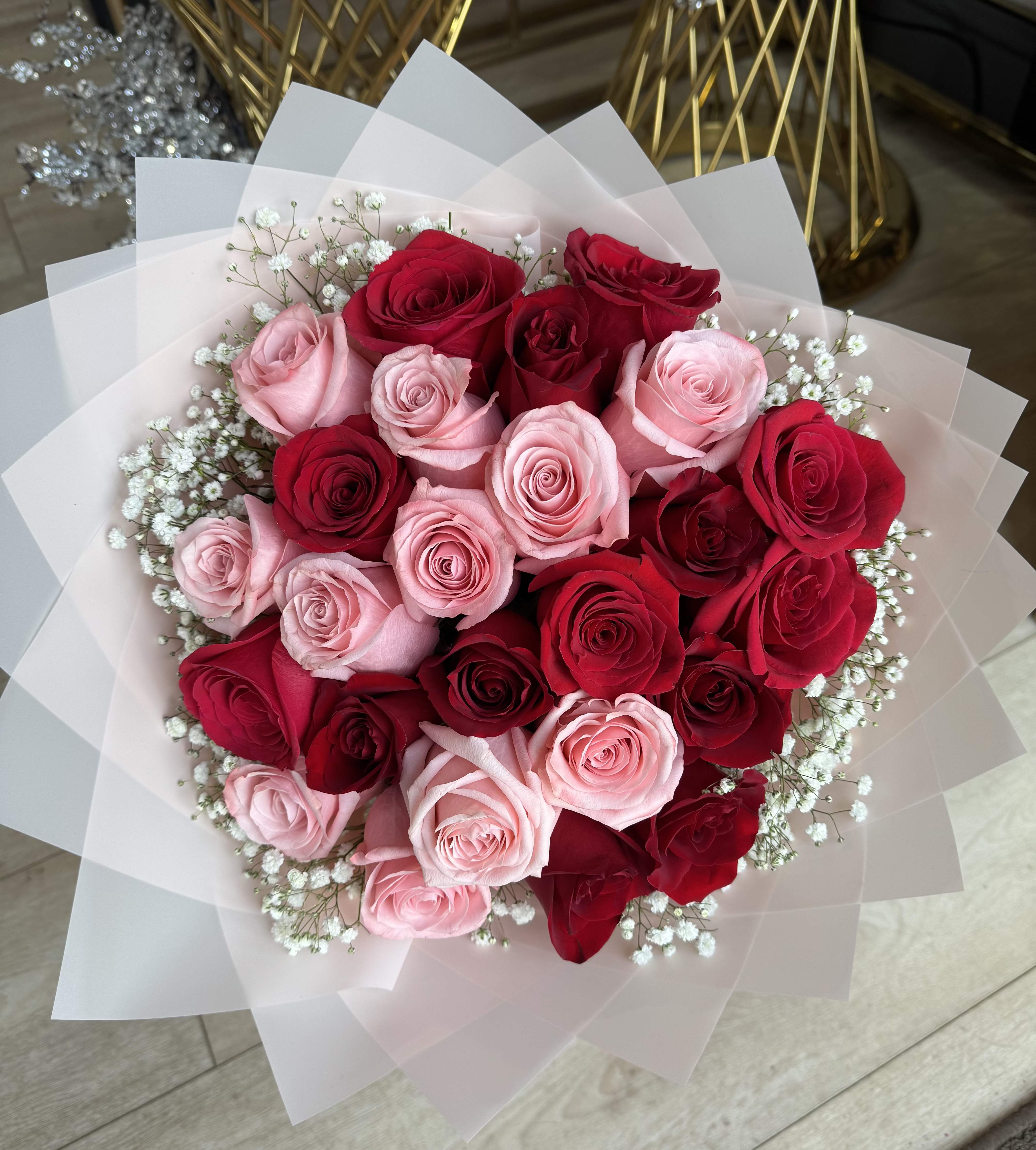 Bouquet of red and pink roses wrapped in white paper