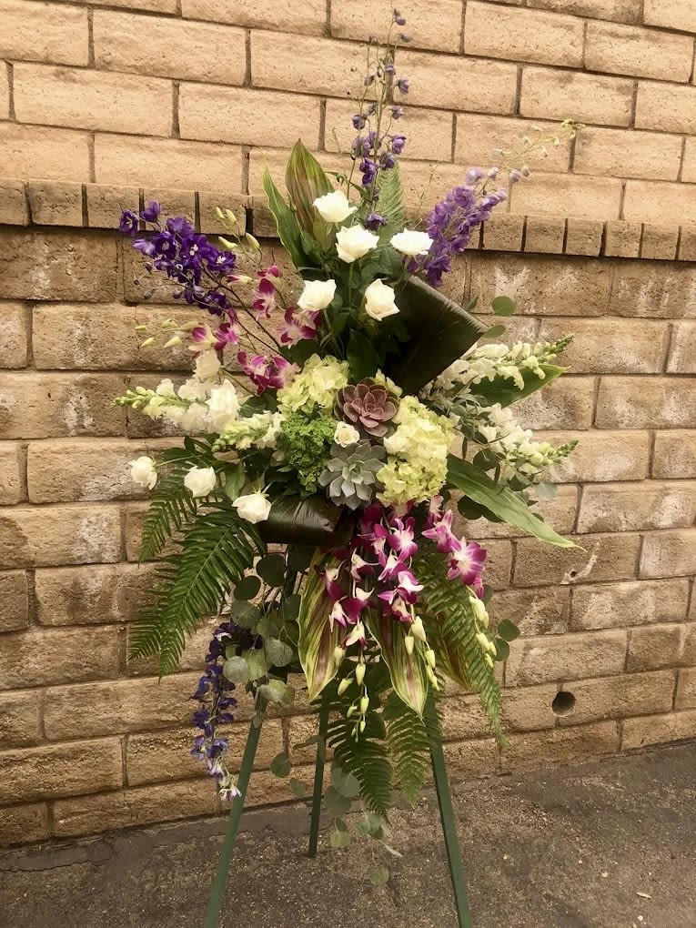Tropical Sympathy Spray - This sympathy spray has  tropical feel, elegant look with orchids and succulents. Recipe: Delphium, Snapdragons, Hydrangaes, Lisianthis, Roses, Dendrobium Orchids, fern, Succulents, and tropical leaves.