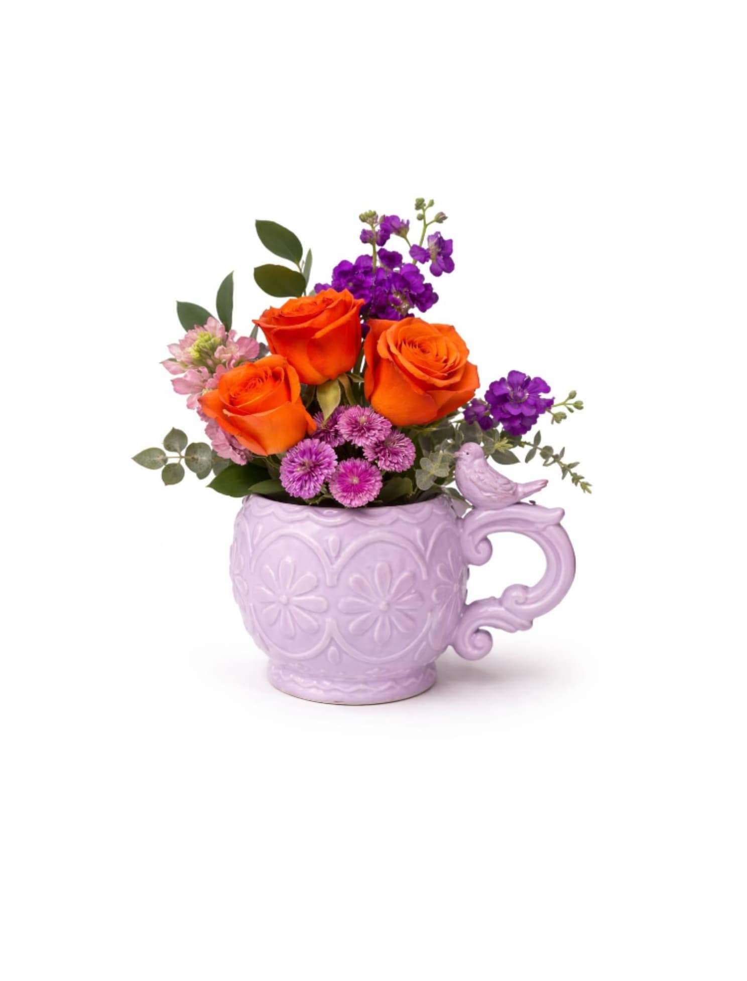 Garden Bird Bouquet - A cheerful spring floral arrangement designed in a charming lavender mug with a delicate bird accent. Bright seasonal blooms and fresh greenery create a joyful and vibrant design perfect for celebrating the beauty of spring.  Better For: Spring celebrations, Easter, Birthdays, Thank you, Get well, Just because.   Flowers and vase may vary based on seasonal availability. Our designers will select the freshest blooms while maintaining the same overall style, color palette, and feel of the arrangement.