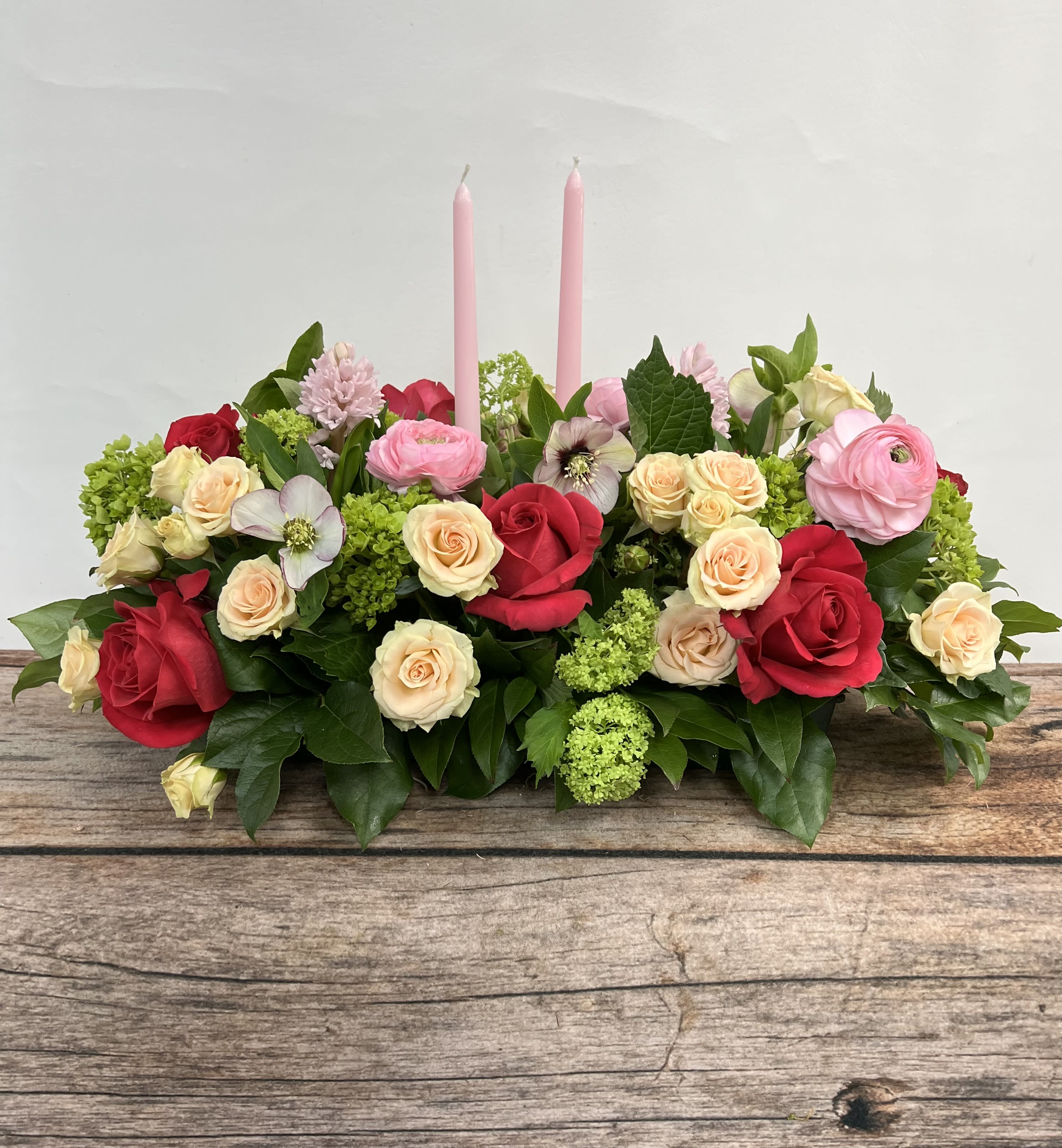 Traditional Spring Centerpiece - A low, oblong style centerpiece full of spring flowers. Perfect to host guests or to bring to a celebration. Approx. 27" long