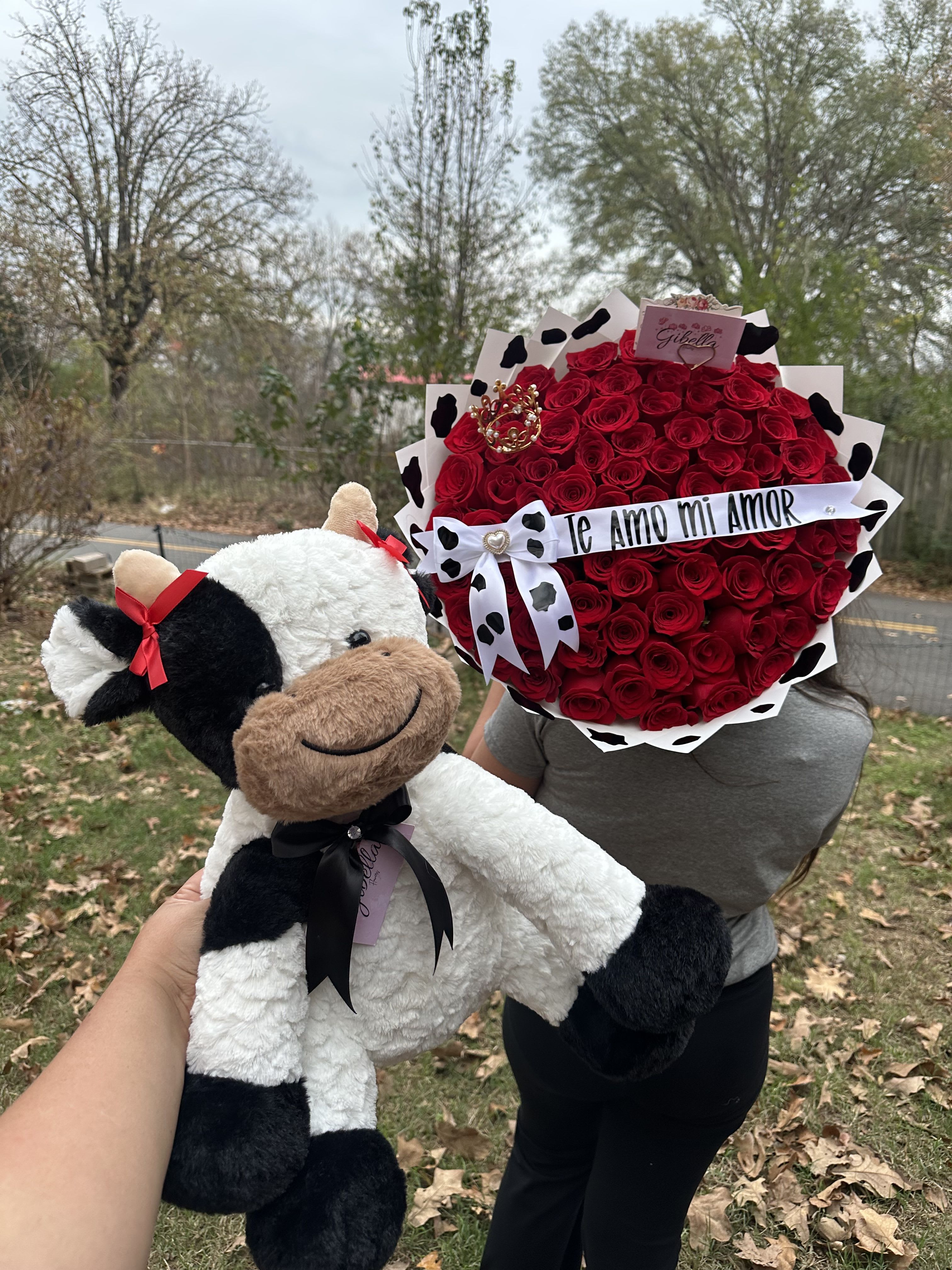 Red rose bouquet with a ribbon and a plush cow toy