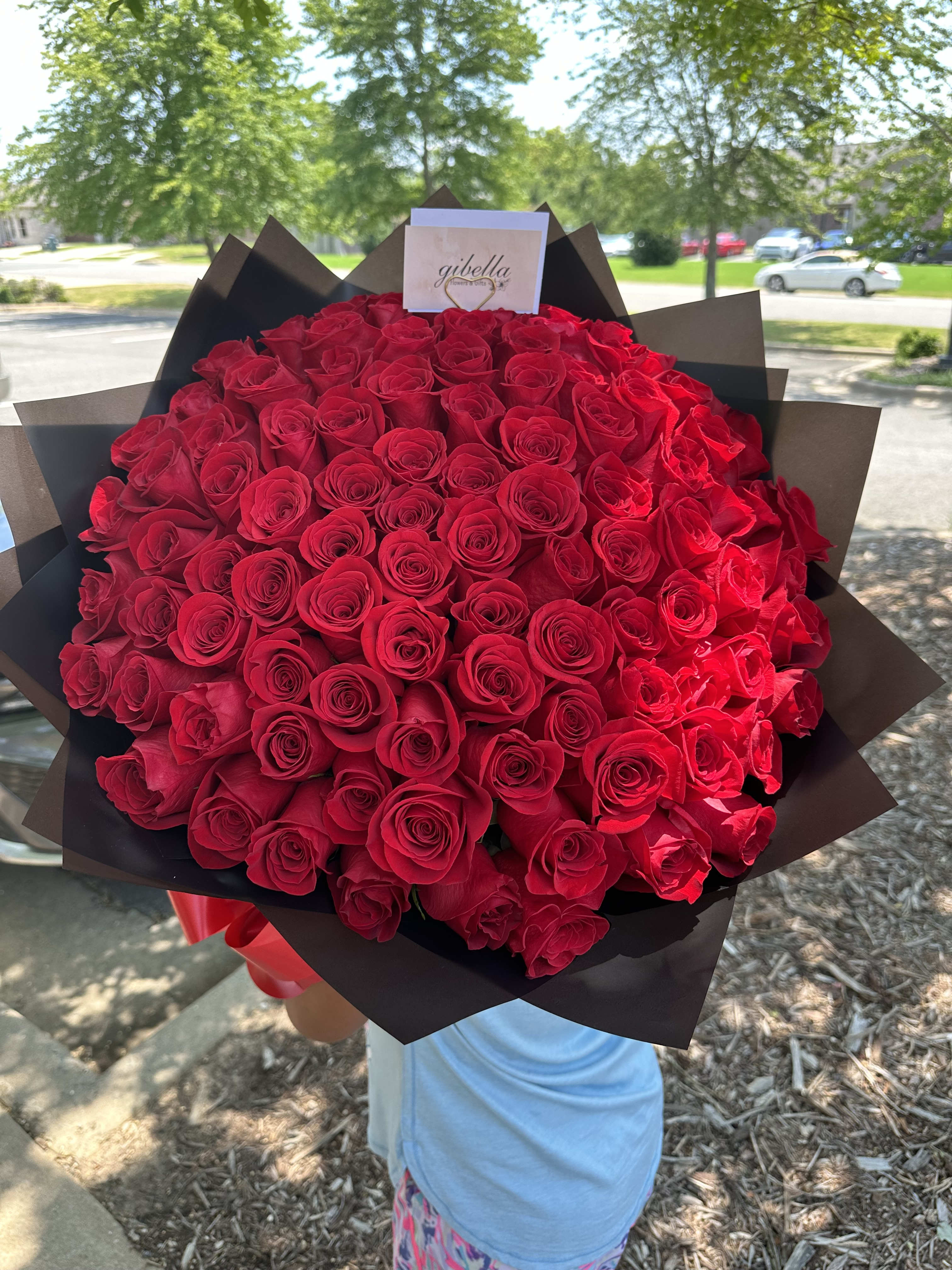 Large bouquet of red roses wrapped in dark paper