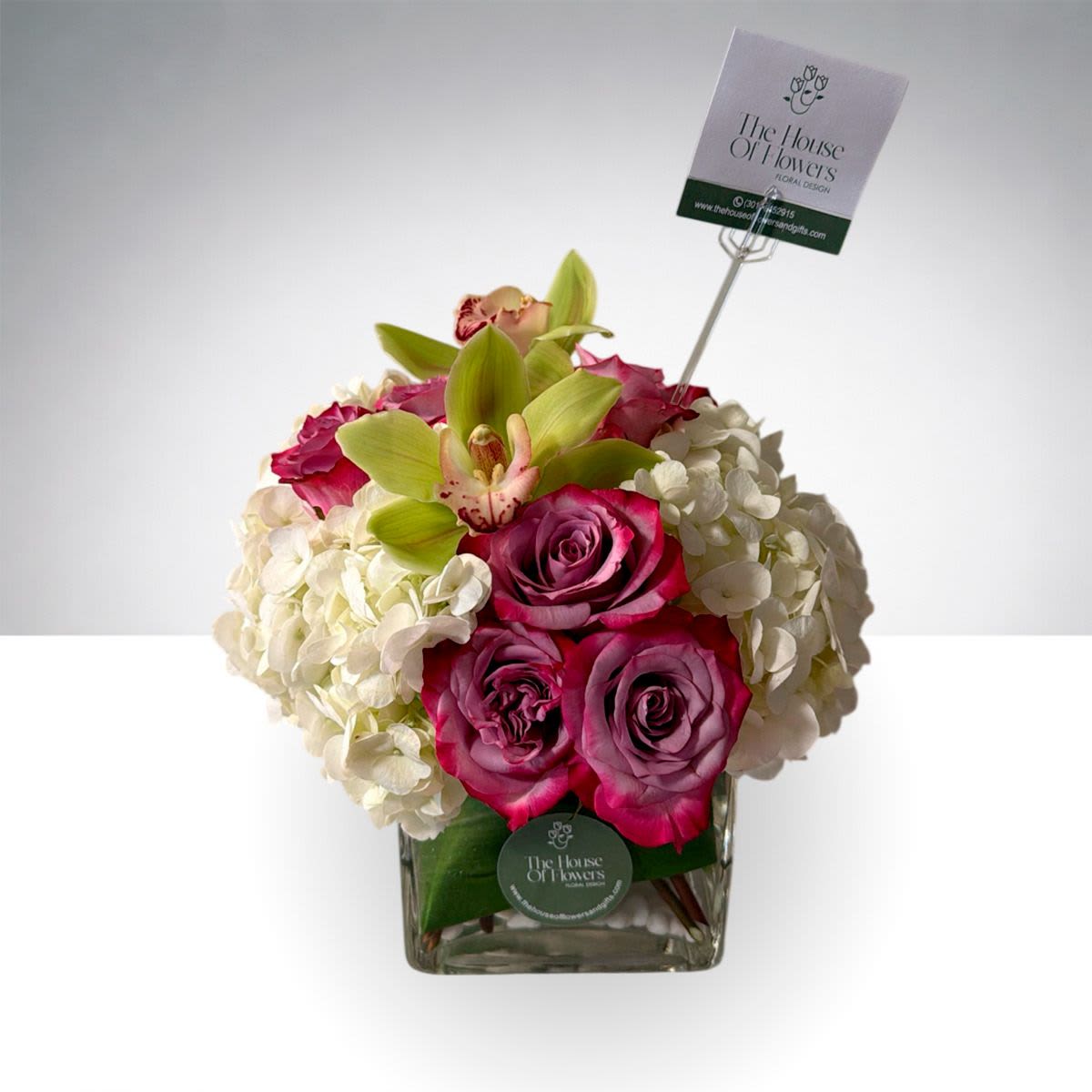 Pink Harmony by The House of Flowers - A refined floral arrangement featuring premium pink roses, lush white hydrangeas, and delicate cymbidium orchid blooms, beautifully arranged in a modern glass cube vase with fresh greenery. The blend of vibrant pink and soft ivory tones creates a balanced and elegant design that brightens any space.  Perfect for birthdays, thank you gifts, celebrations, or simply to make someone smile.