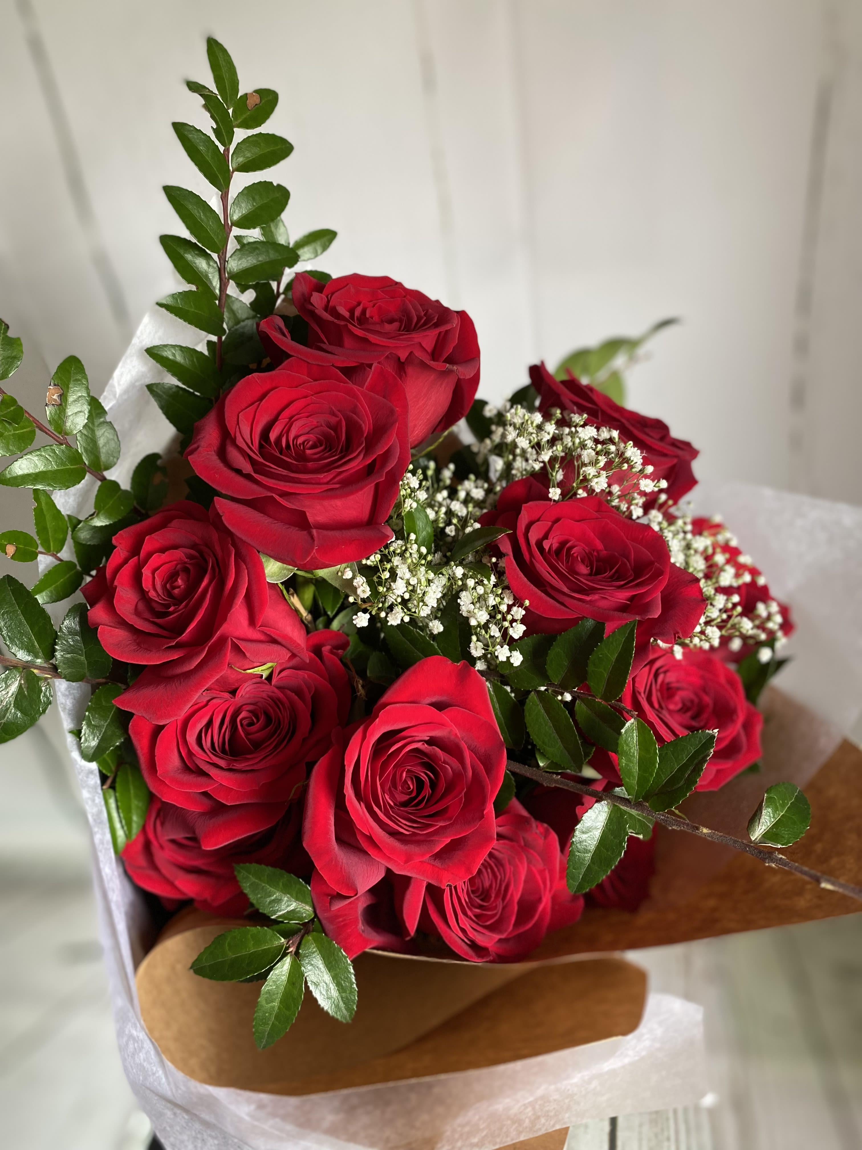 Dozen Roses - Wrapped - Michaleen's classic dozen roses wrapped with baby's breath and greens.  *Please call us at 607-257-3203 to request a dozen in another color. We can accommodate most requests with at least 24 hours' notice &amp; always carry other colors in stock!