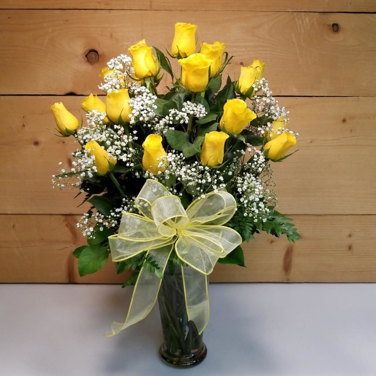 24 Yellow Roses Vased - Two Dozen Yellow Roses featuring 24 Long-stemmed yellow roses elegantly displayed in a clear glass vase. We use only the finest roses available to ensure a spectacular presentation. This version features generous amounts of baby's breath and various popular greens to make an even grander impression.