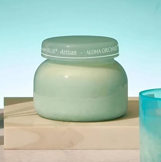 Aloha Orchid Candle - A tropical scent in a seaglass-blue container, the luxury of Aloha Orchid will transport you to where the sun is shining every day. 