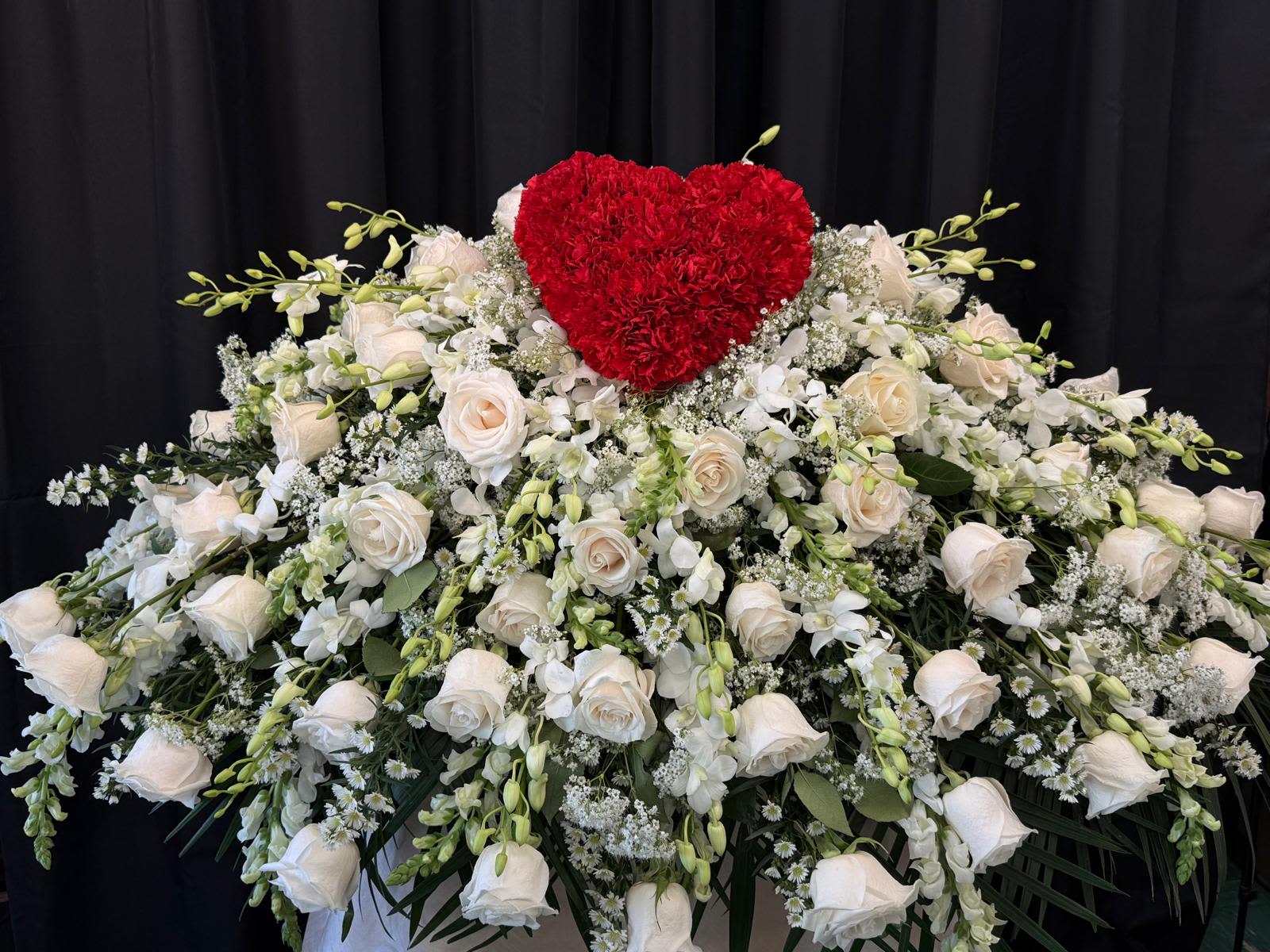 A Heart of Peace Casket Cover  - The Heart of Peace casket cover is a timeless expression of love, comfort, and remembrance. Designed in all-white blooms, it symbolizes purity, reverence, and eternal rest. A delicate heart formed at the center serves as a quiet tribute to enduring love and cherished memories.