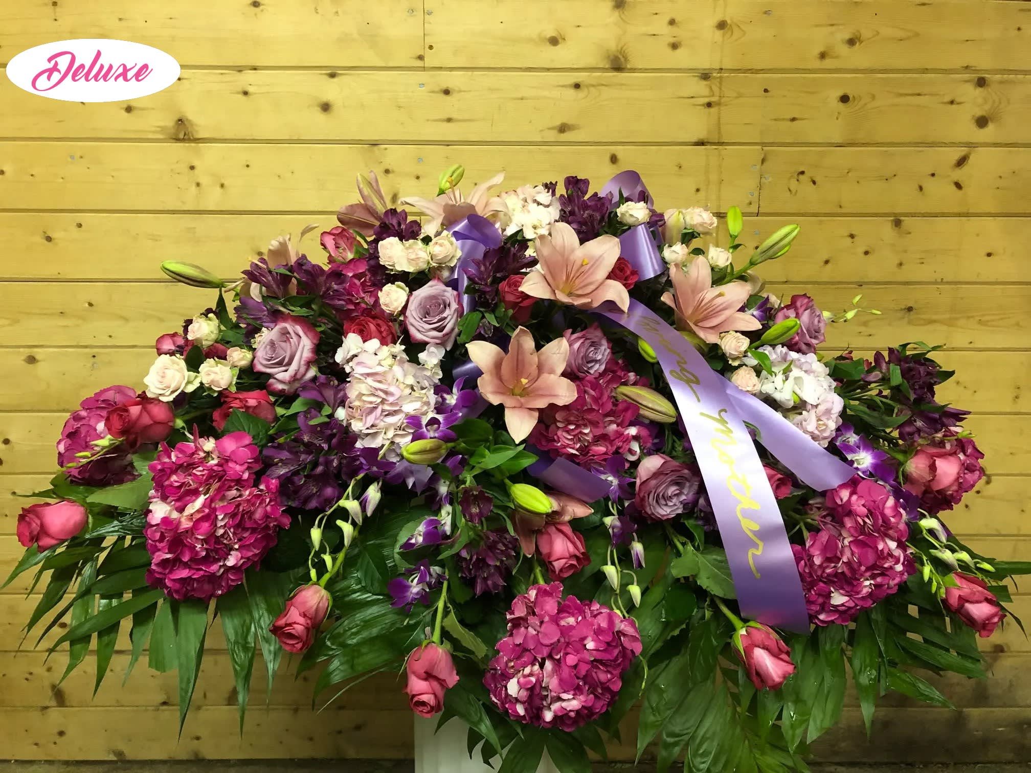 PInk &amp; Purple Casket Cover  -  A classic casket spray adorned with purple carnations, pink lilies, lavender roses and pink hydrangea is perfect to pay your respects in a significant way. 