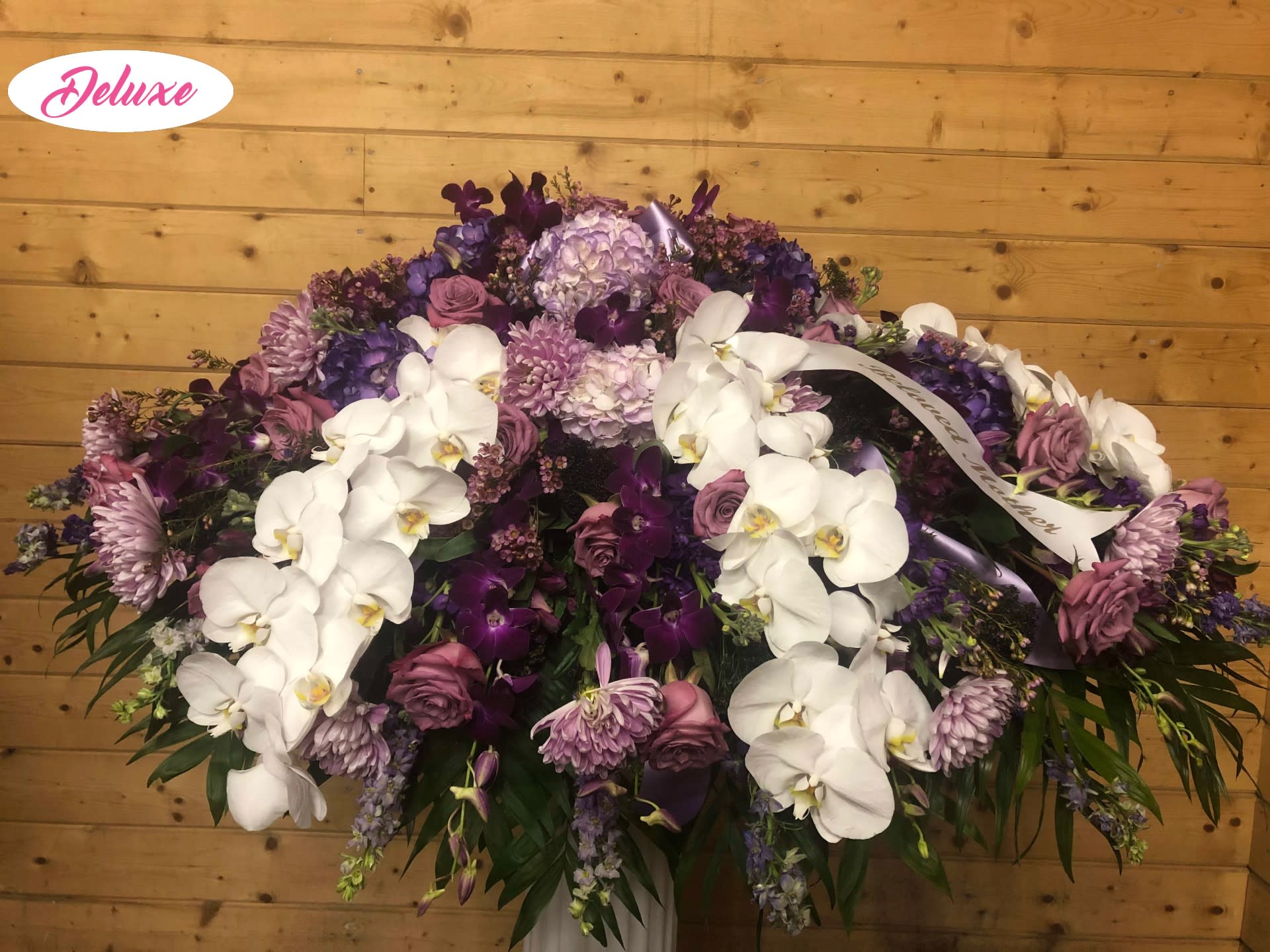 Lavander and Phalaenopsis Casket Cover  - This lovely assortment of lavender and purple seasonal flowers is complimented by beautiful Phalaenopsis Orchids. A lovely and elegant way to honor a loved ones memory. 