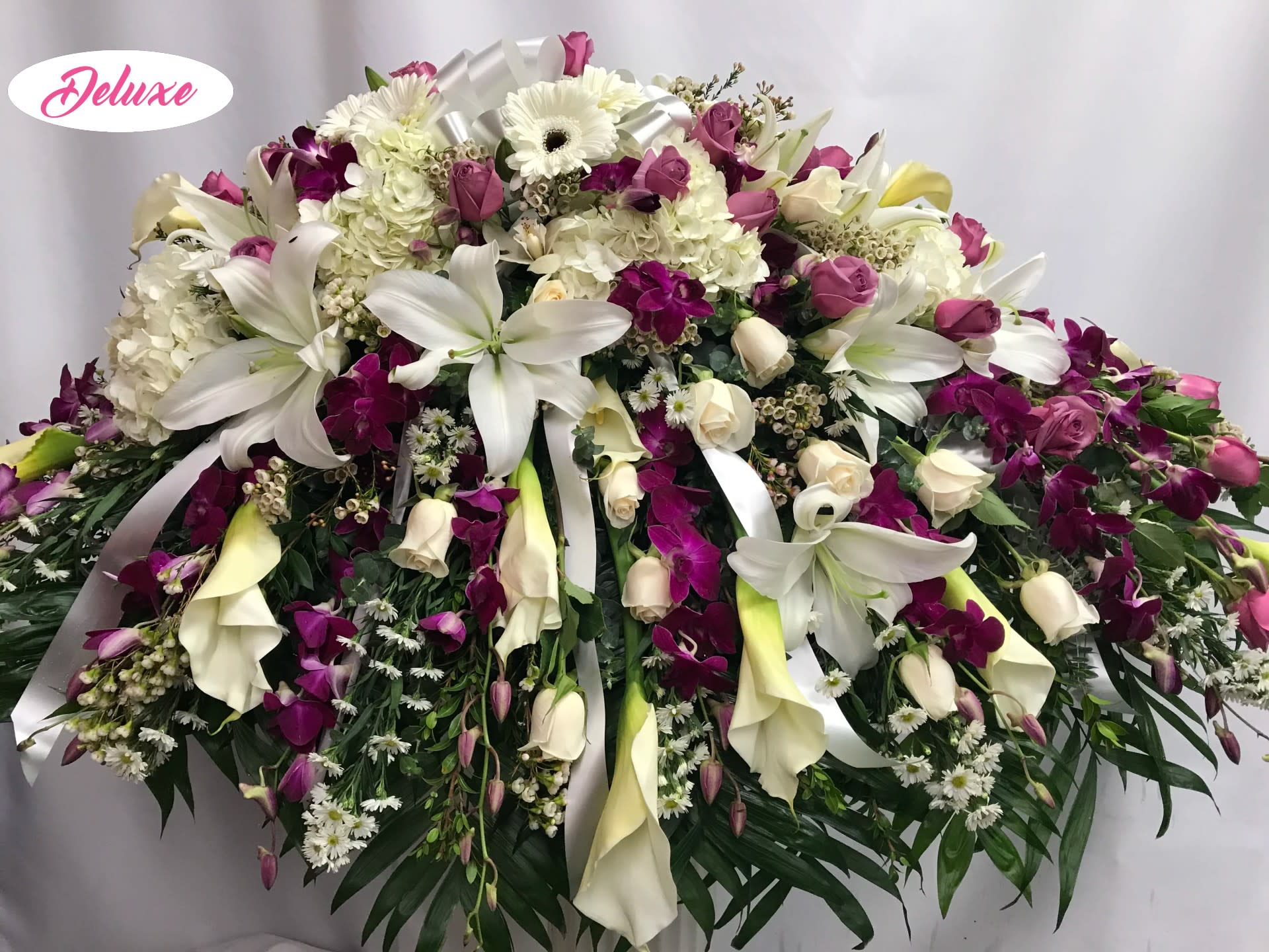 Loving Memories Casket Cover - this casket cover is beautiful with large white callas, white &amp; lavender roses, purple orchids, white lilies and other seasonal flowers in white &amp; purple. 