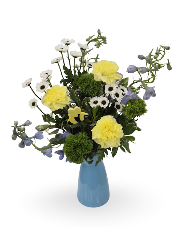 Coastal Glow - Select this bold and beautiful " Coastal Glow" arrangement featuring yellow carnations, blue belladonna, and white chrysanthemums accented with greenery. Finished with a bee pick to add an extra touch of charm.
