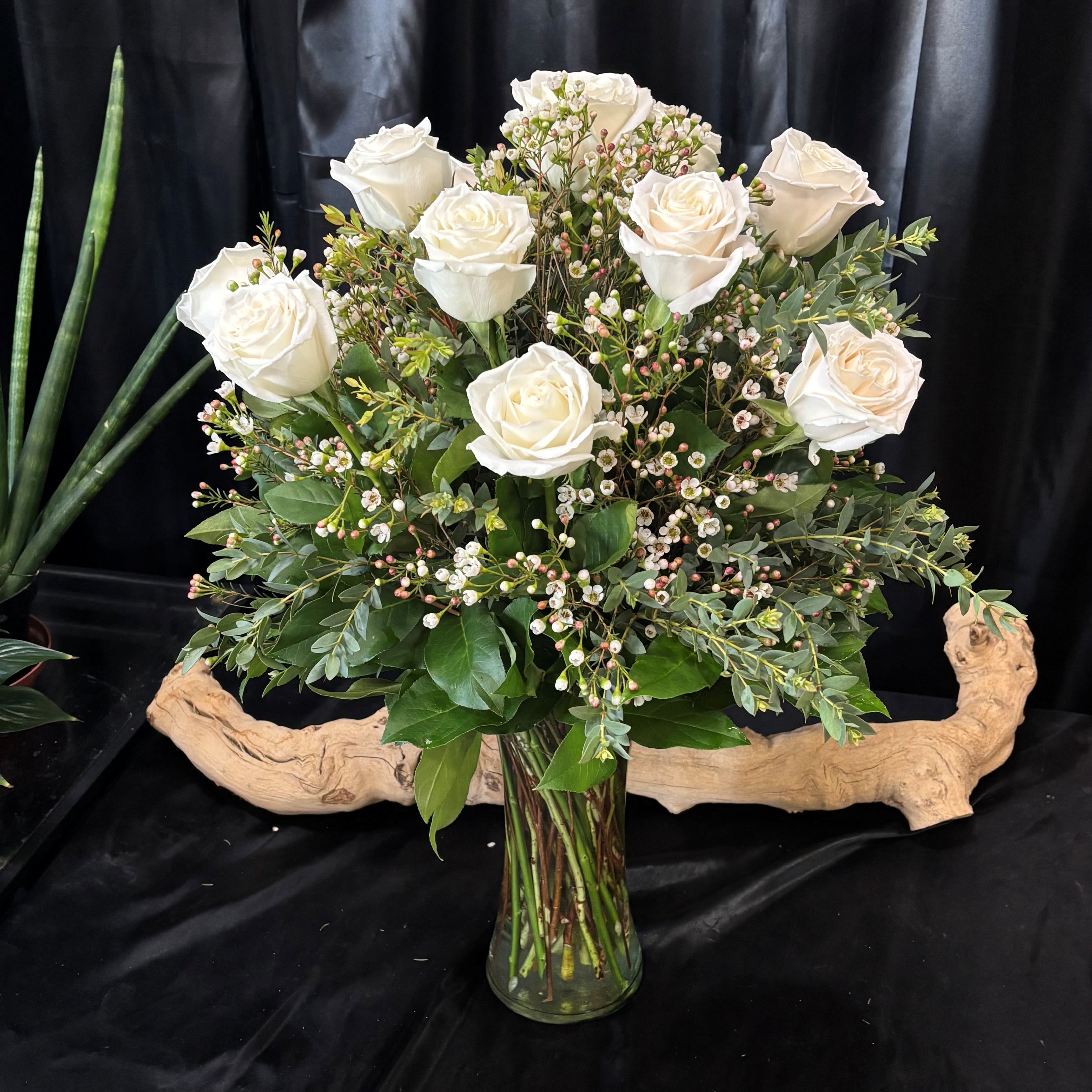 1 Dozen White Long Stem Roses with premium greens and filler - A dozen white roses in a glass vase