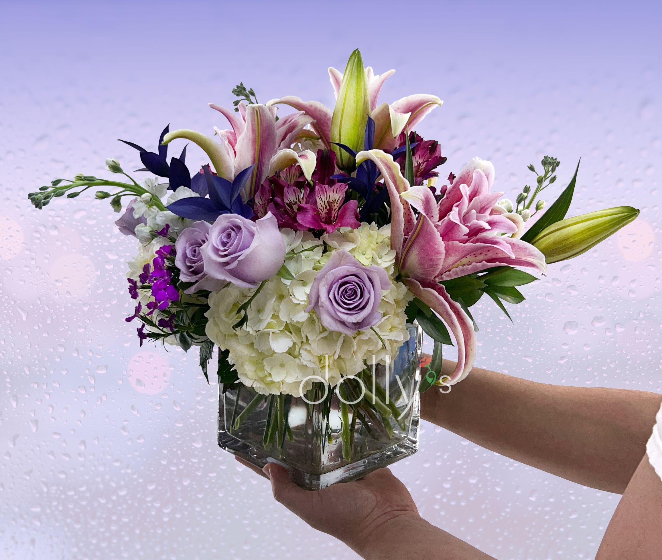 Purple Rain Kiss  - Roses, lilies, and mums in varying hues of purples and lavender.