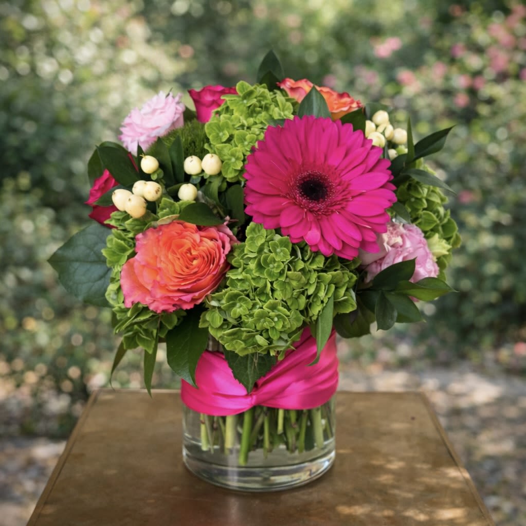Pink French Twist - Pink French Twist – Luxury Flower Arrangement | Wilmington, Delaware Florist Add a chic pop of color to any occasion with Pink French Twist, a stylish floral arrangement handcrafted by your local Wilmington, Delaware florist. This eye-catching design features lush green hydrangea, delicate white hypericum berries, vibrant orange roses, and bold hot pink gerbera daisies, expertly arranged in a classic glass vase. Finished with a signature pink French twist satin ribbon, this arrangement blends modern flair with European-inspired elegance. Perfect for birthdays, celebrations, thank-you gifts, or just because. Available for delivery in Wilmington, DE and the surrounding area including Newark, Kennett Square and Chadds Ford. Made with premium, fresh flowers and available for local same-day delivery, this arrangement brings color, sophistication, and joy to any space.  Tax free. Same day hand delivery.