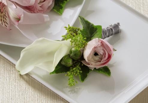 FTD Enchantment Boutonniere - The FTDÂ® Enchantmentâ¢ Boutonniere is the perfect complement to the   overall look of your wedding party. A single white mini calla lily and a   pink ranunculus bloom are accented with variegated ivy and solidago   tied together with a silver gray ribbon to create a wonderful complement   to the style of your groomsmen. Approx. 4âH x 2âW.   