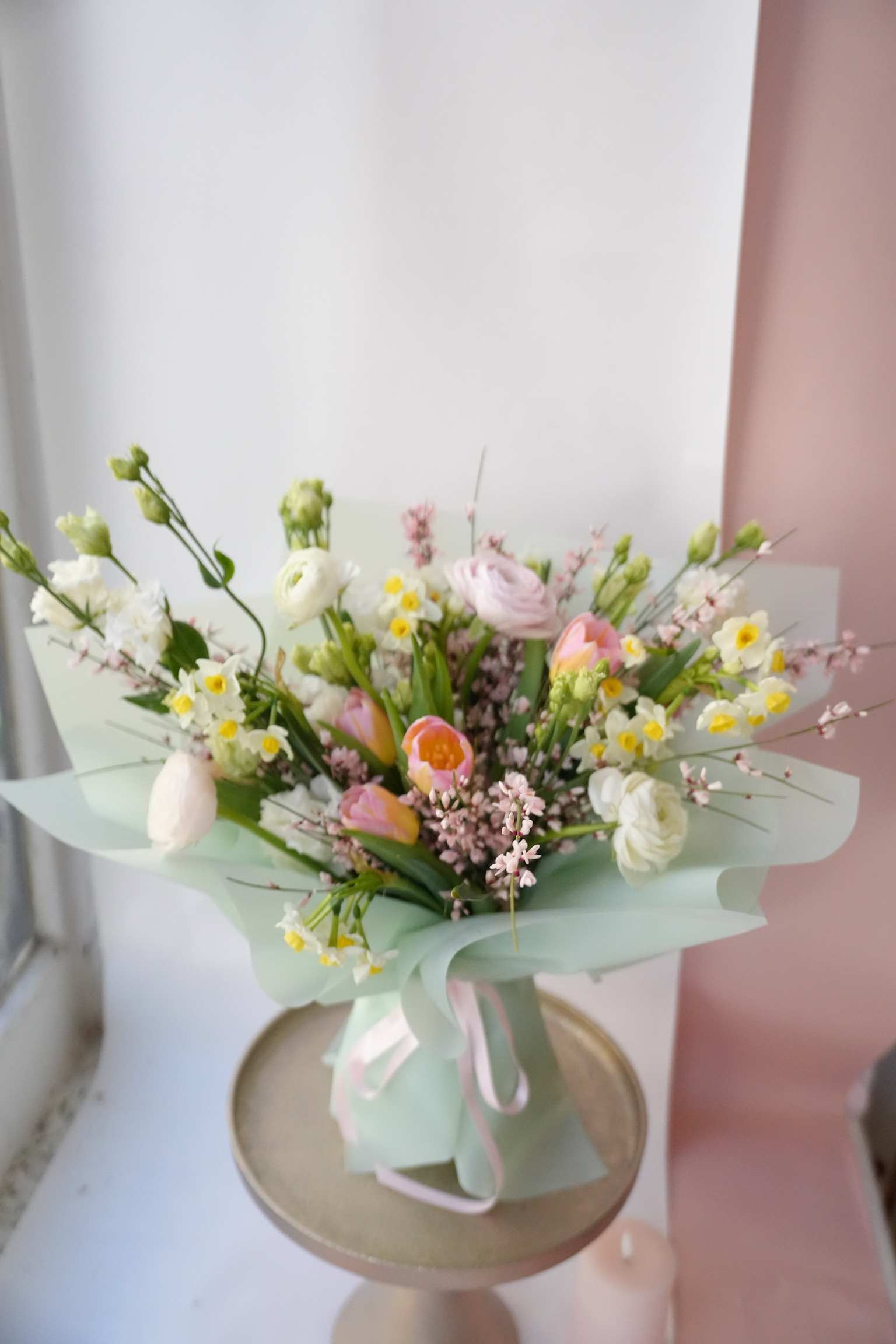 Blossom - A bouquet made with delicate blooms in various shades of pink, white, and yellow accents, announcing the arrival of spring. It's a beautiful combination of ranunculus, tulips, genistra, and daffodils.  Order your luxurious floral bouquet today for fast, same-day delivery in Hoboken!