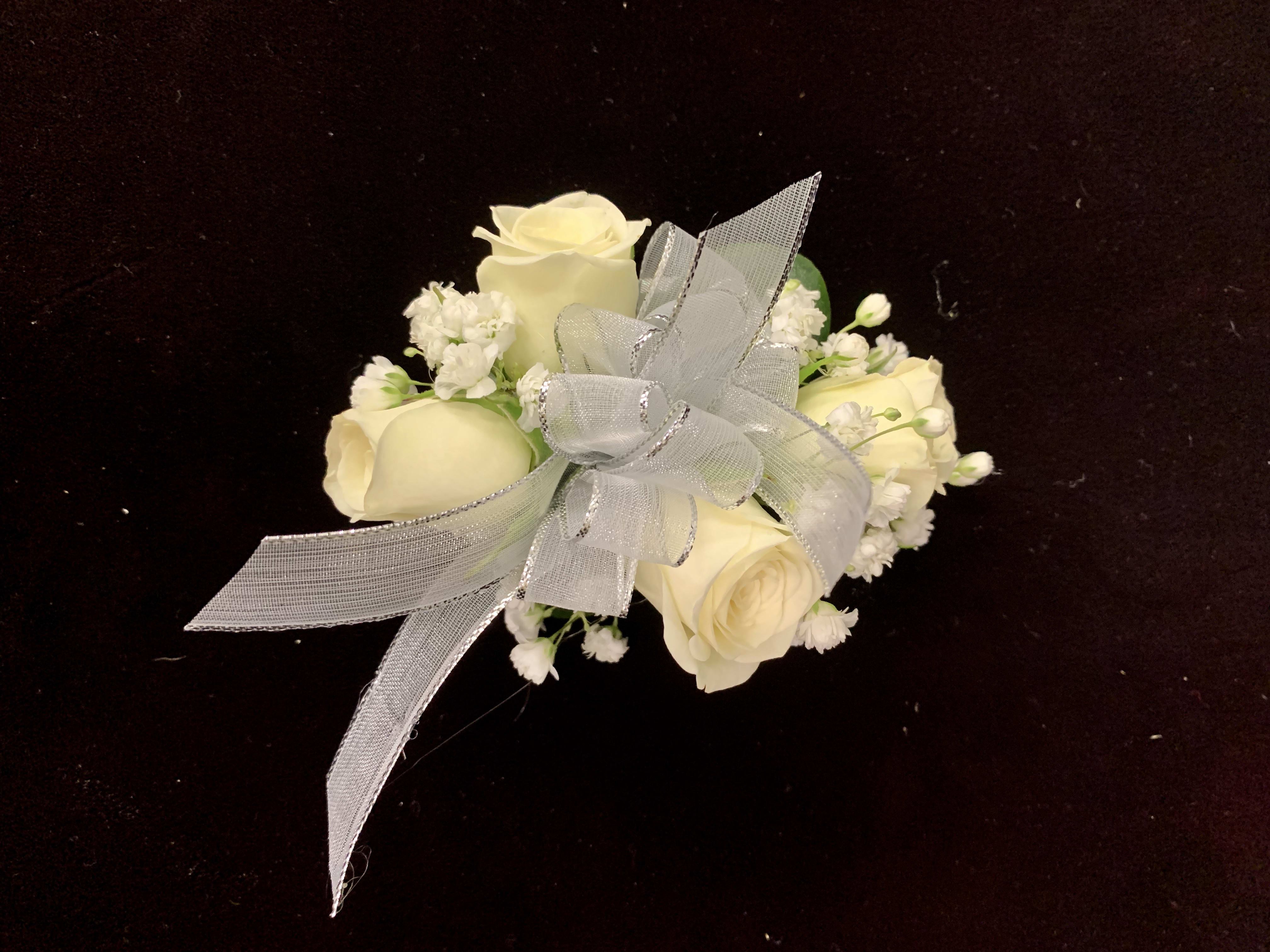 White Rose Wristlet - White sweetheart roses on a wristlet with accent flowers and your choice of ribbon color. Other colors available for roses, but white will be second choice if color choice is not. Specify in special instructions.  Please call us to place your order if pick up is within next 48 hours. Phone: 703-356-9377