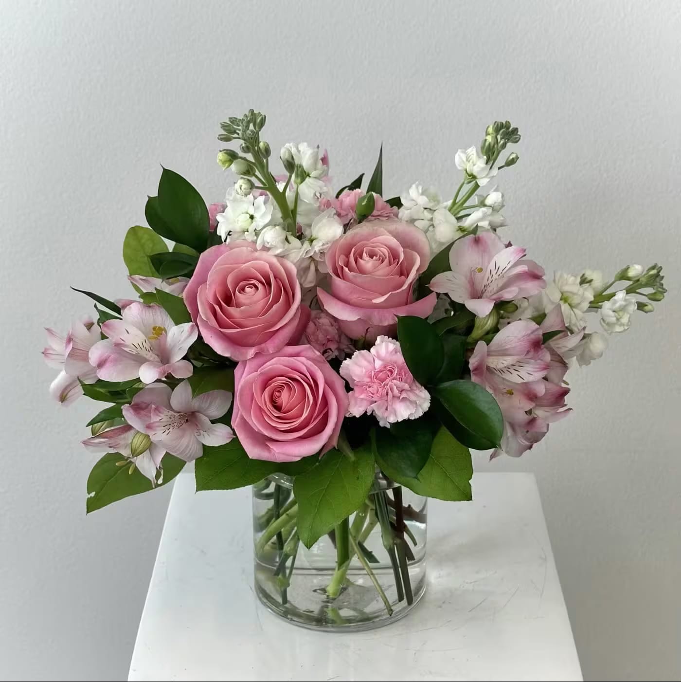 At The Ballet - Discover the enchanting "At the Ballet" flower arrangement, a graceful tribute to elegance and poise inspired by the delicate beauty of classical dance. This romantic pink bouquet features soft pink alstroemerias symbolizing warmth, affection, and devoted friendship, paired with classic pink roses that whisper gratitude, admiration, and gentle romance. Creamy white stock adds an air of lasting beauty, purity, and contented joy, while vibrant pink carnations bring heartfelt appreciation and timeless maternal love—making this design perfect for expressing tender sentiments. The harmonious blend of blush and white tones creates a light, feminine palette reminiscent of a ballerina's tutu twirling across the stage. Ideal for birthdays, anniversaries, Mother's Day, thank-you gestures, or simply to brighten someone's day with sophistication and charm. Long-lasting blooms ensure your message of grace and appreciation lingers beautifully. Elevate any occasion with "At the Ballet"—a floral masterpiece that captures movement, emotion, and effortless elegance in every petal. Order this stunning pink flower bouquet today for delivery and let its poetic beauty dance into their heart!