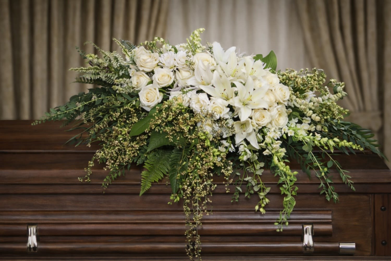 Garden Elegance Casket Spray  - The Garden Elegance Casket Spray from FloralFabulous is a refined and timeless tribute designed to honor a loved one with grace, purity, and serenity. This elegant arrangement features classic white roses and pristine lilies, beautifully complemented by lush, flowing greenery.  The all-white floral palette symbolizes peace, remembrance, and eternal love, making this arrangement a traditional and meaningful choice for funeral and memorial services. Designed to rest gracefully atop the casket, this spray creates a soft, elegant focal point that brings comfort and tranquility to family and friends.  The Garden Elegance Casket Spray is ideal for those who wish to express sympathy with understated beauty and timeless sophistication. Its flowing design and fresh white blooms reflect purity, respect, and heartfelt remembrance.  FloralFabulous proudly provides funeral flower delivery and casket sprays in Round Rock, TX and the greater Austin area, helping families express sympathy with elegance, dignity, and care.