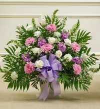 Lavender Elegance Floral Basket - A graceful and soothing floral basket featuring a harmonious blend of white roses and white asters, accented with purple and lavender cremons for a soft, elegant touch. Enhanced with fresh greenery and finished with a lavender ribbon bow, this arrangement offers a serene and thoughtful expression of sympathy, remembrance, or heartfelt sentiments.